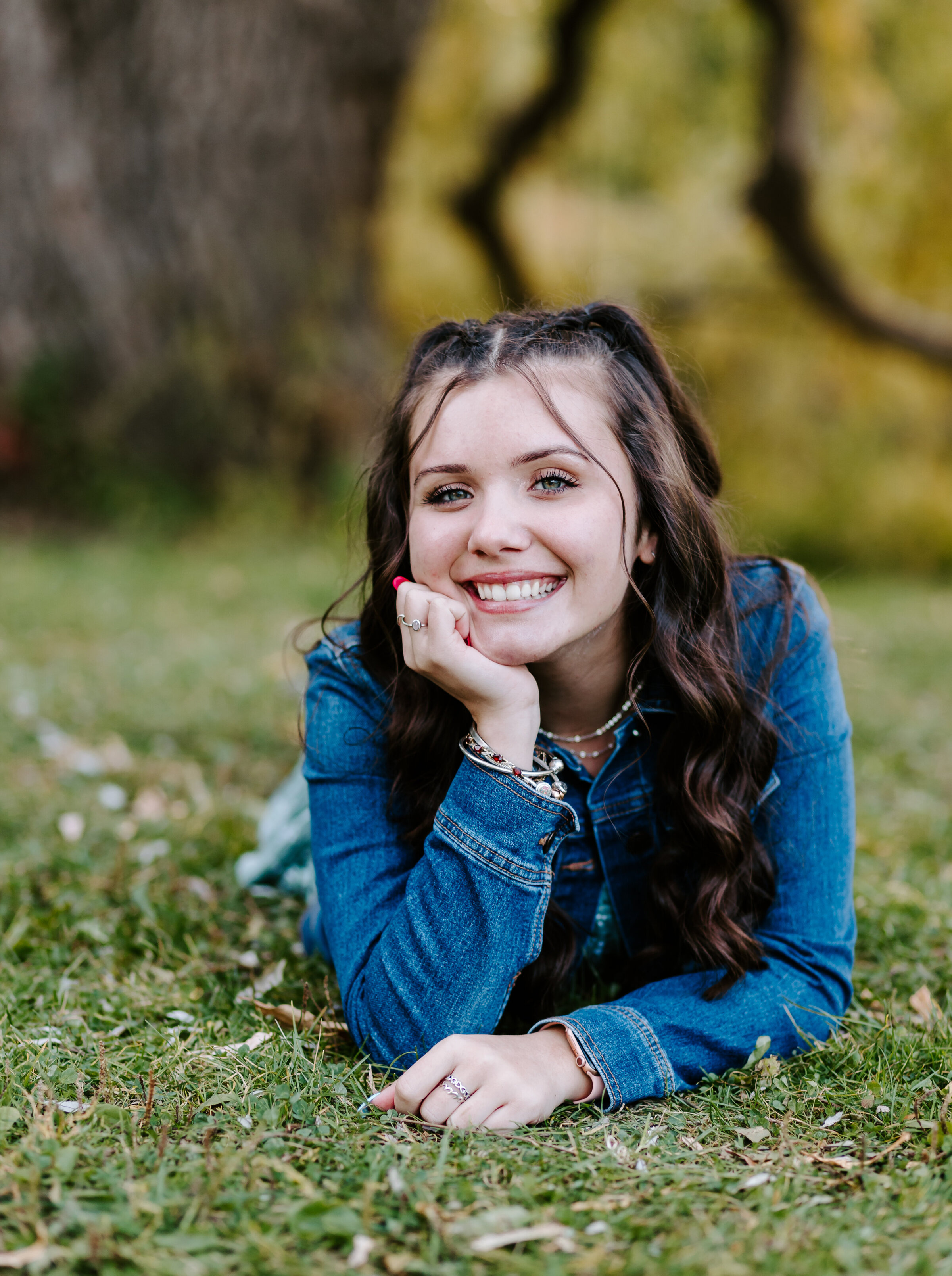 Senior girl smiles at the camera during fall senior session in Londonderry, New Hampshire