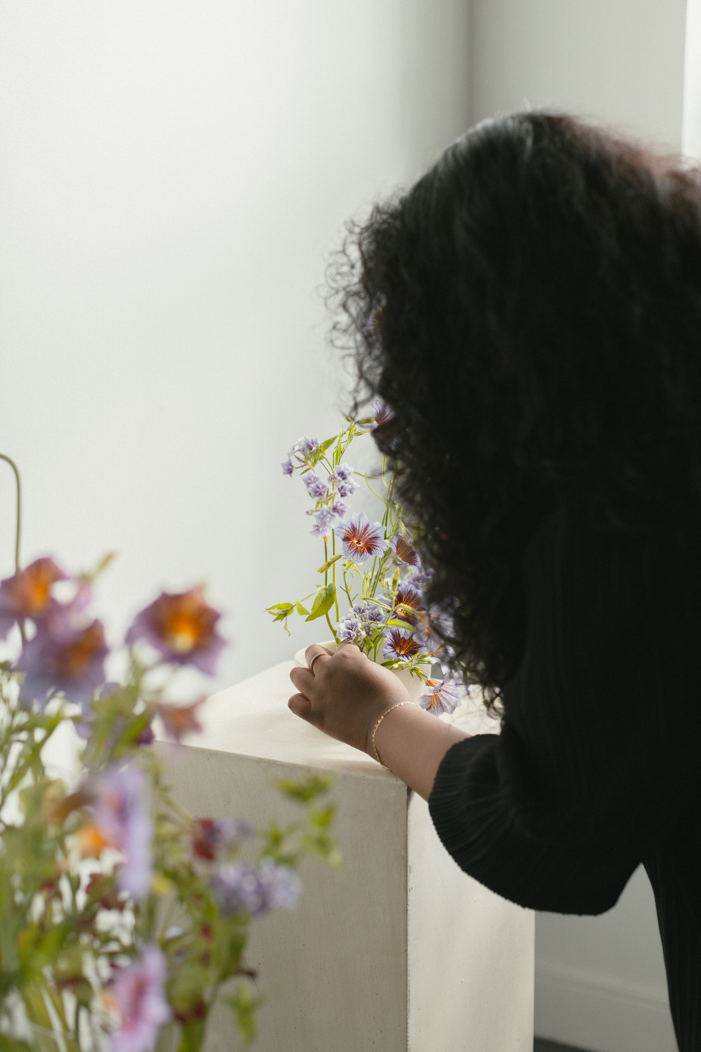 June Bloom Owner, Joanne, arranging floral display.