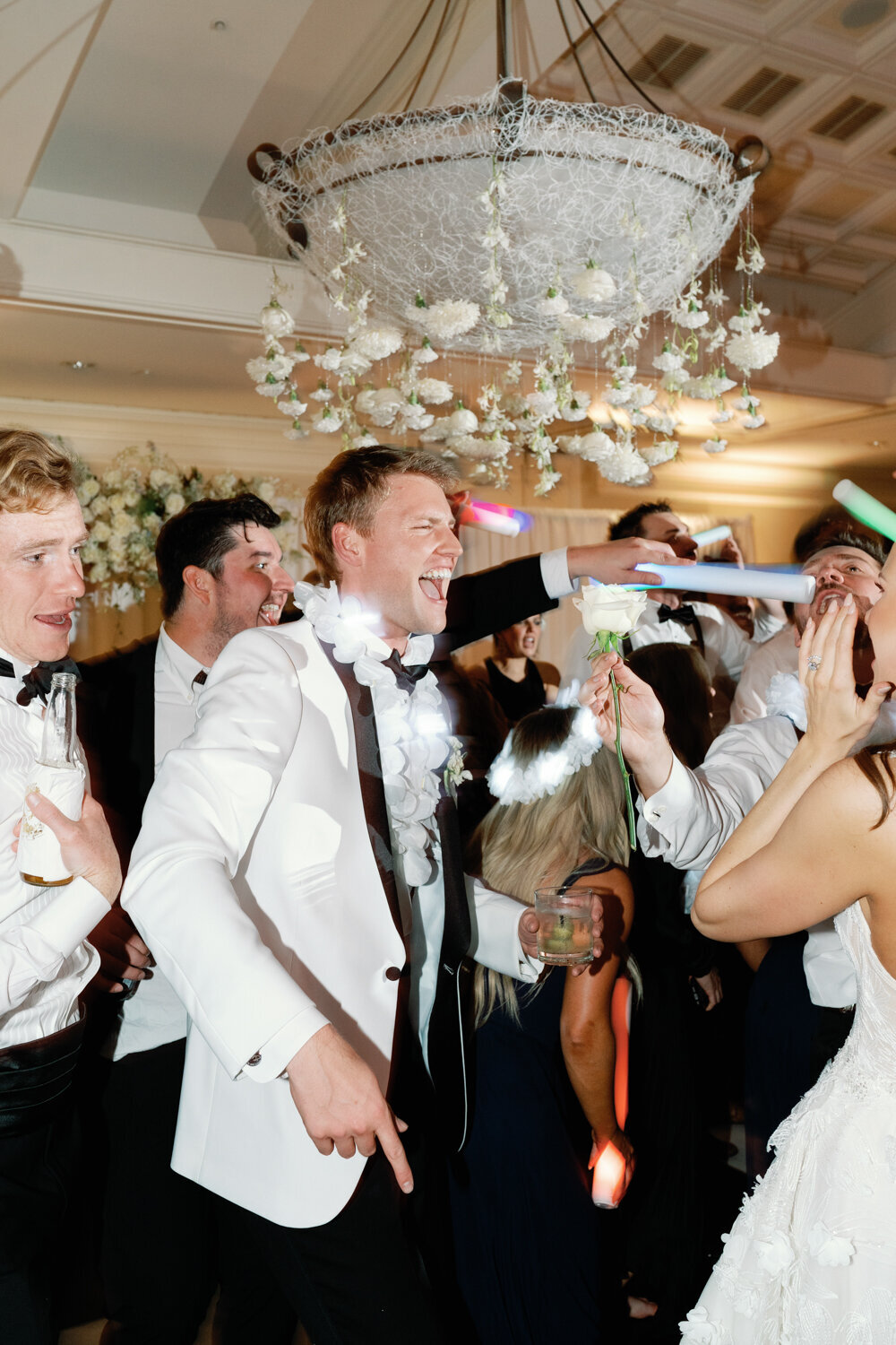 groom in white tux dancing at wedding reception