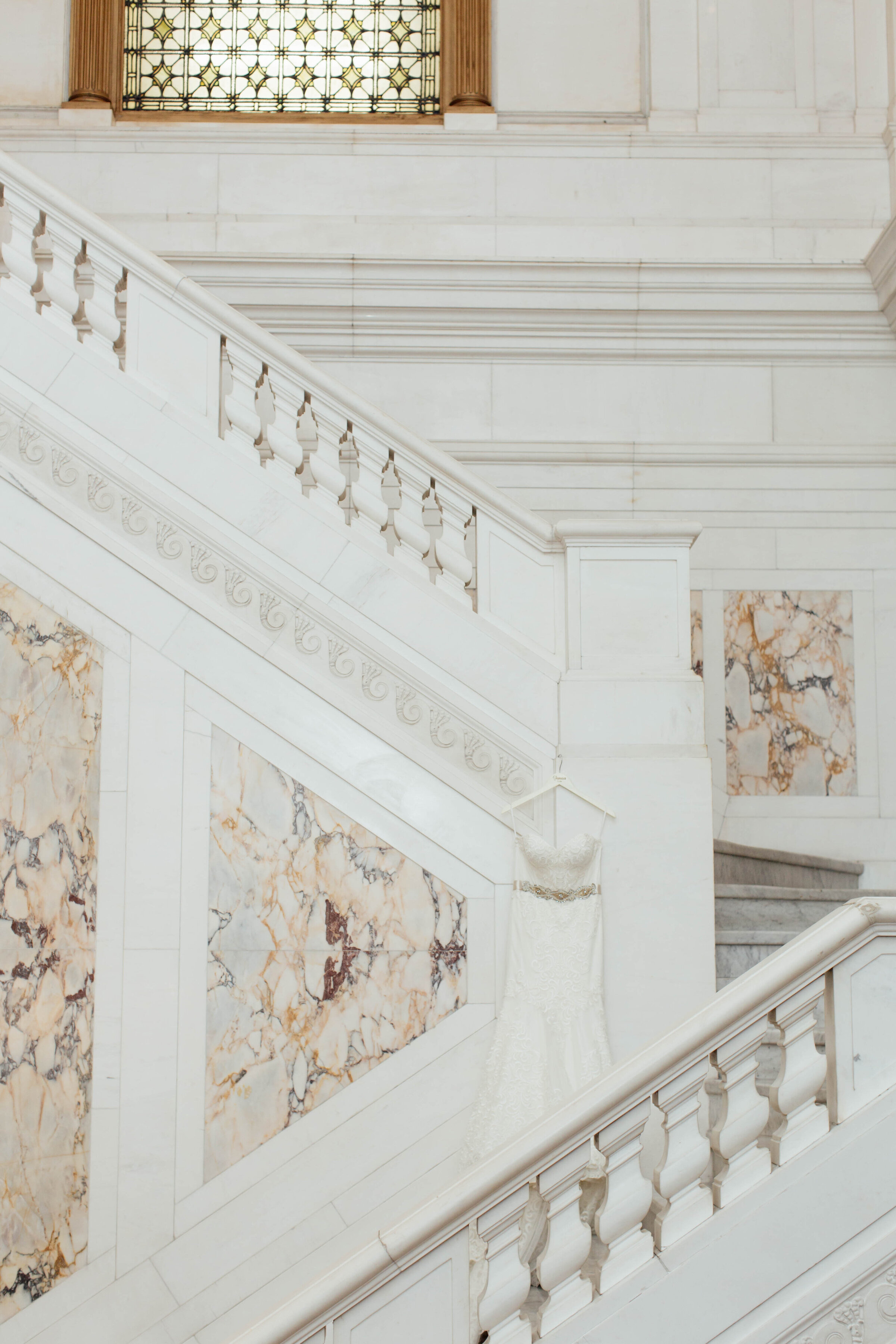Bridal gown hanging on a beautiful marble backdrop.