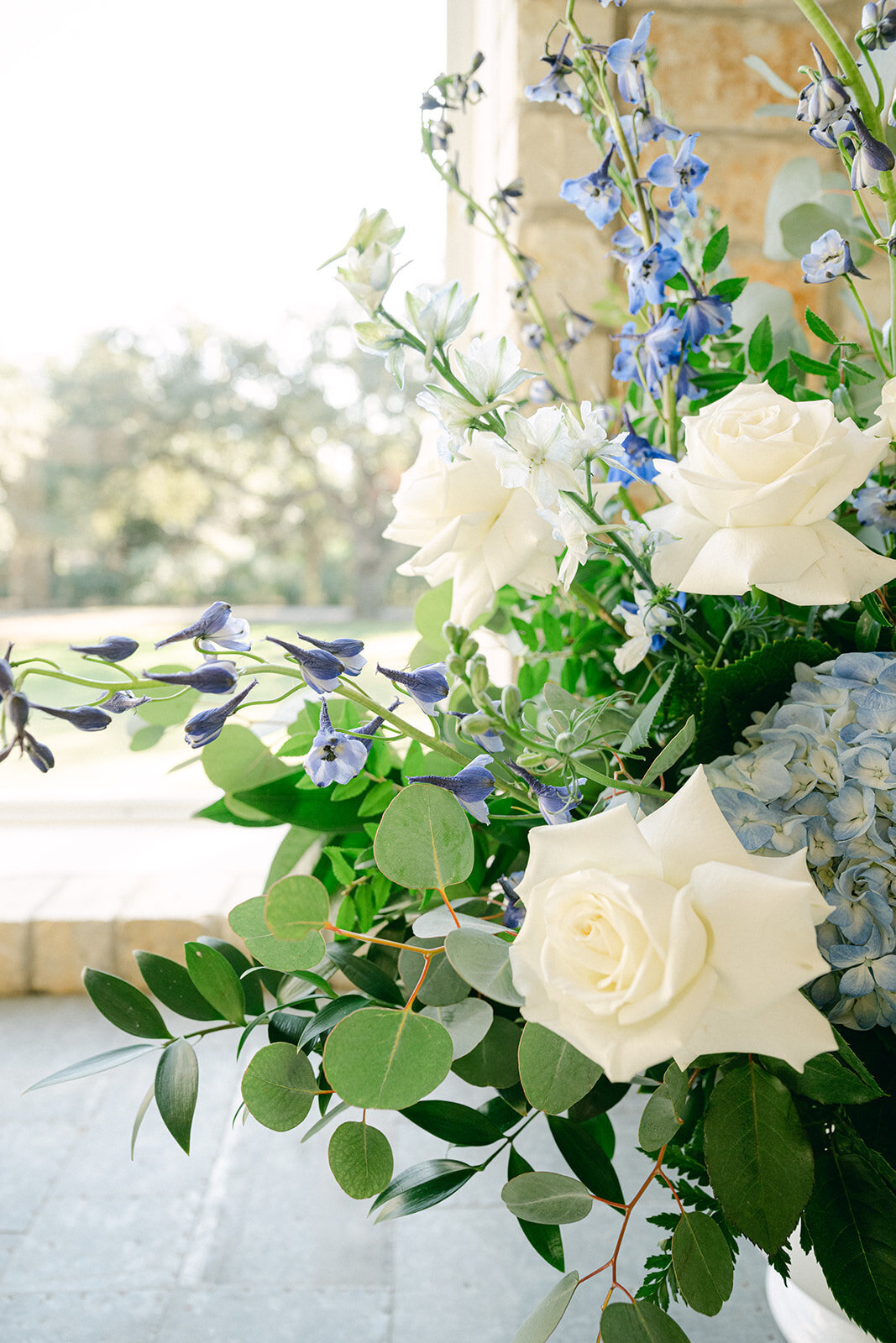 White and blue roses arranged in an organic floral installation for a luxury editorial wedding in the Texas Hill Country.