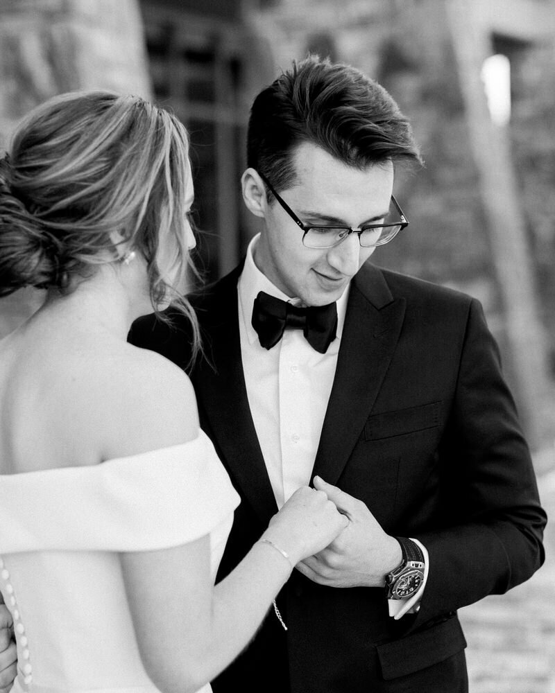 This tender image captures a groom holding his bride's hand during their portrait session at Azuridge Lodge in Southern Alberta. The serene and elegant surroundings of the lodge enhance the intimate moment, reflecting the couple's deep connection and love.