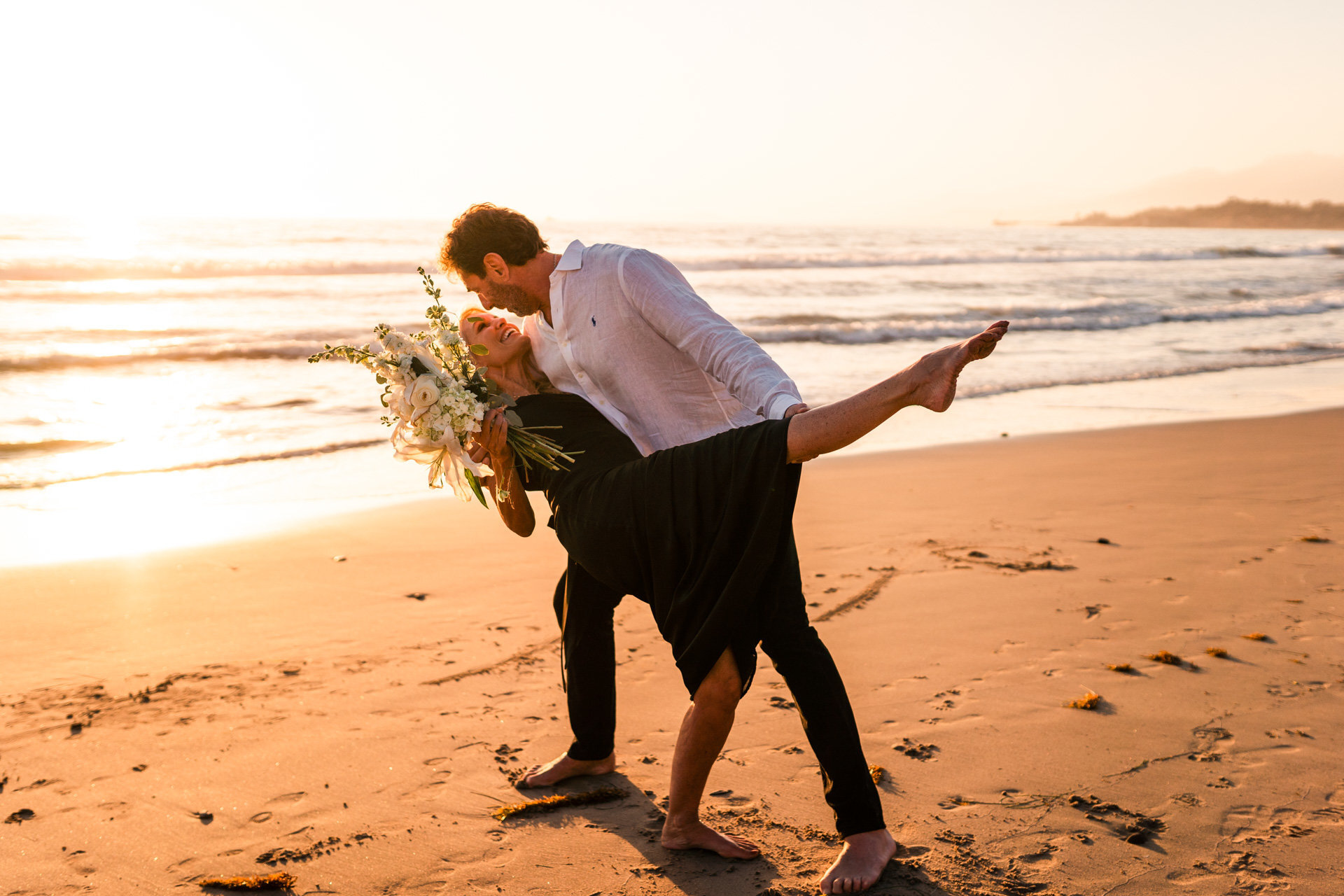 couple dances together at beach elopement