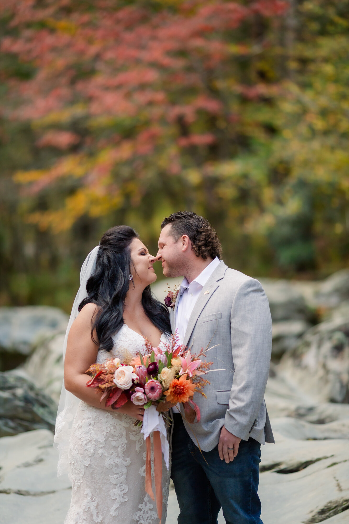 smoky mountain elopement at Greenbrier with bride and groom in the river bed rocks touching their noses together and smiling