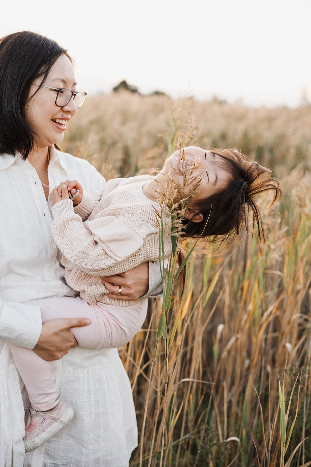 candid family photo of mum and daughter in Melbourne field