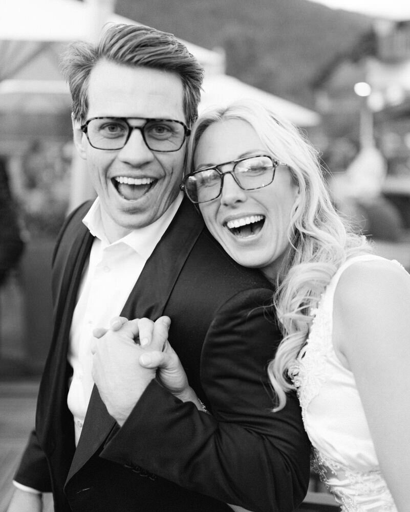 This lively image captures the bride and groom laughing joyously as they head to their after party at the Rose and Crown in downtown Banff. The photograph embodies the couple's happiness and excitement, celebrating their special day with a night of fun and festivity.