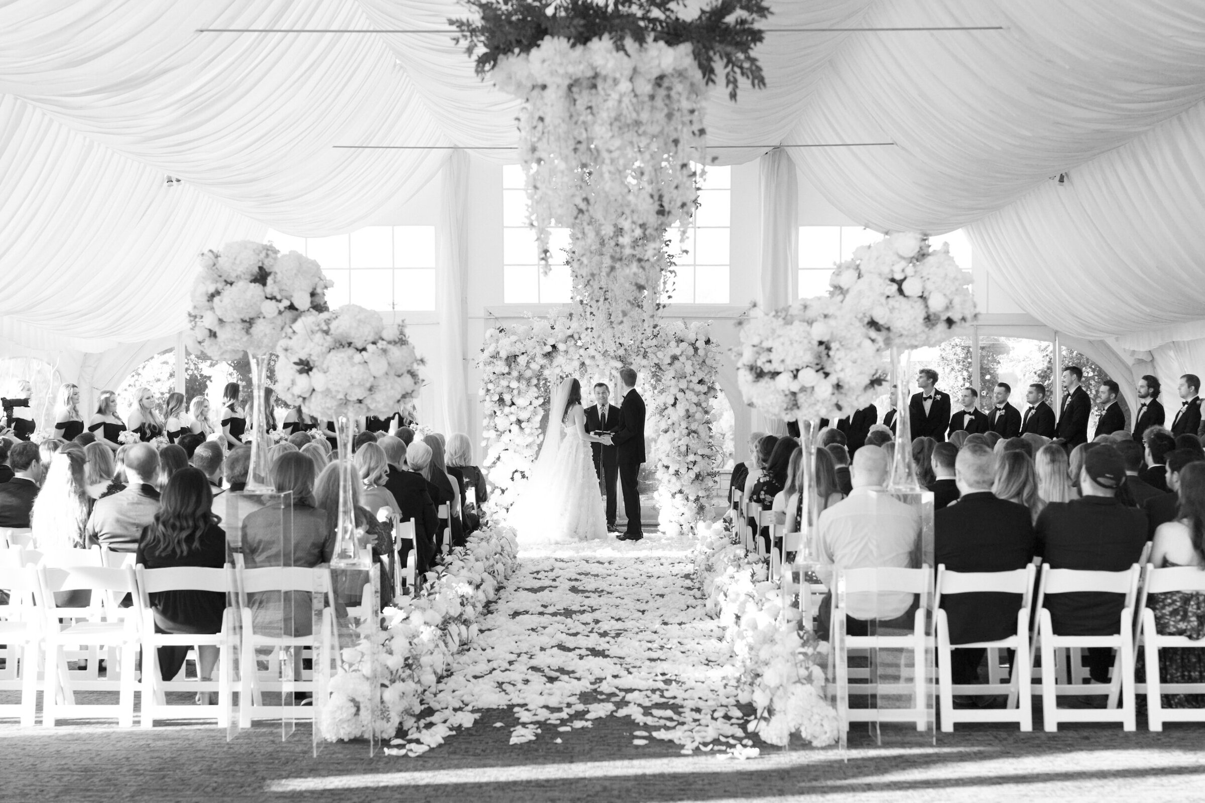 black and white wide photo of wedding ceremony in white tent