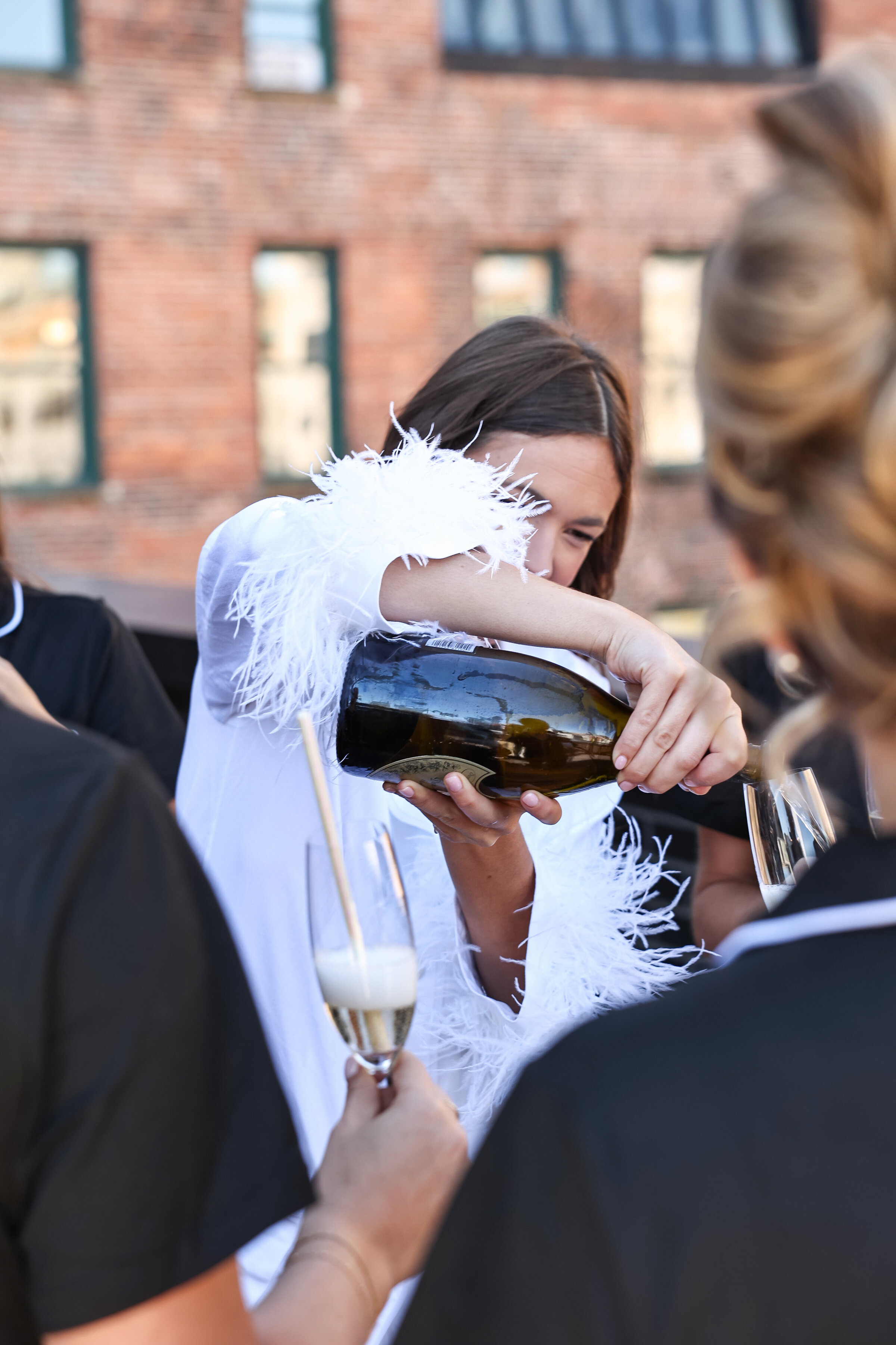 Bride pouring champagne. Detroit wedding Photographer Kai Davis .