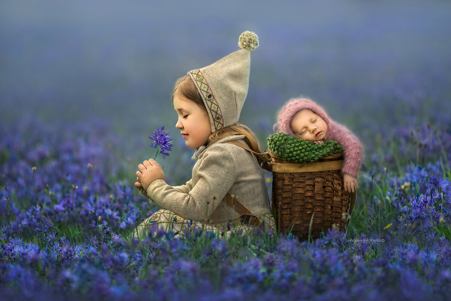 Child and newborn in blue camas flowers.
