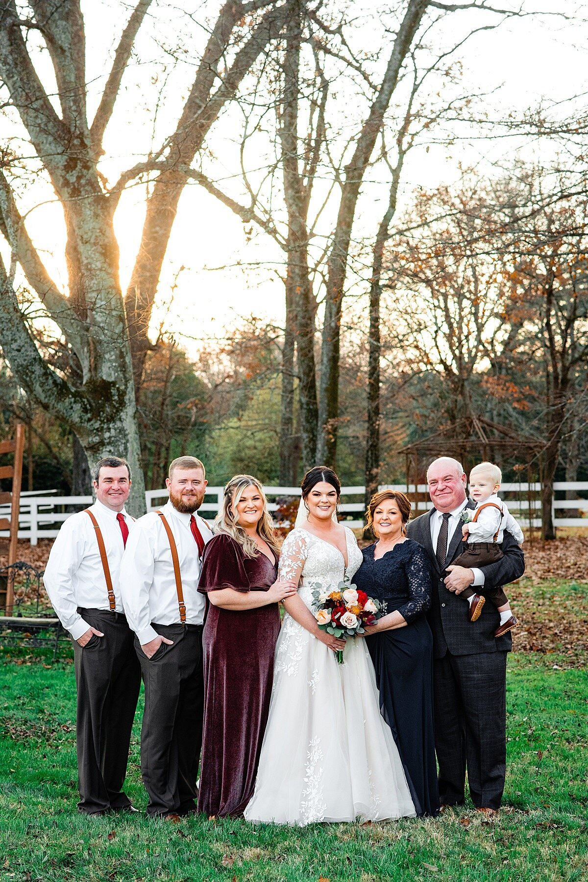 Bride with her family outside for a group portrait on the lawn during golden hour