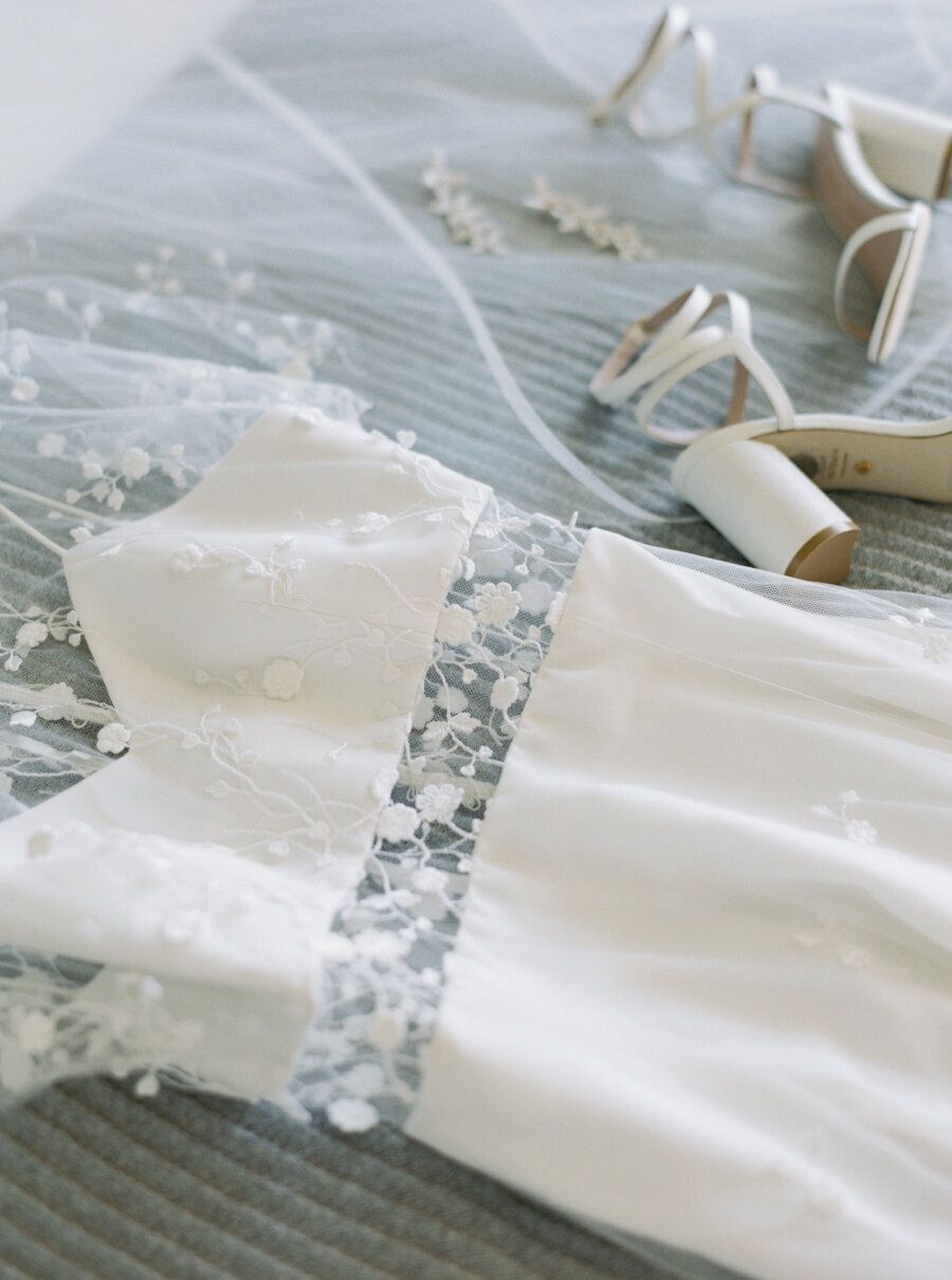 lace delicate tiny bridal dress laying on bed