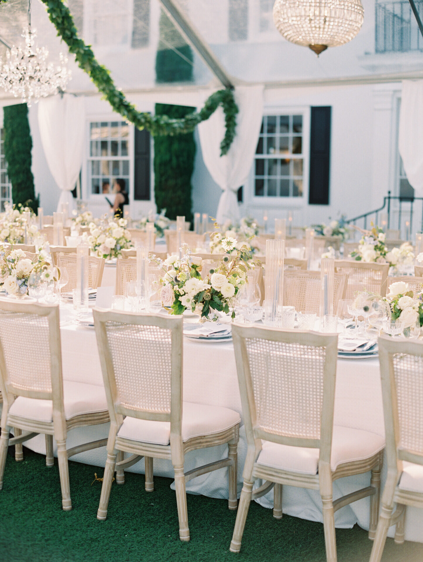 white and green wedding reception setup outside on green grass