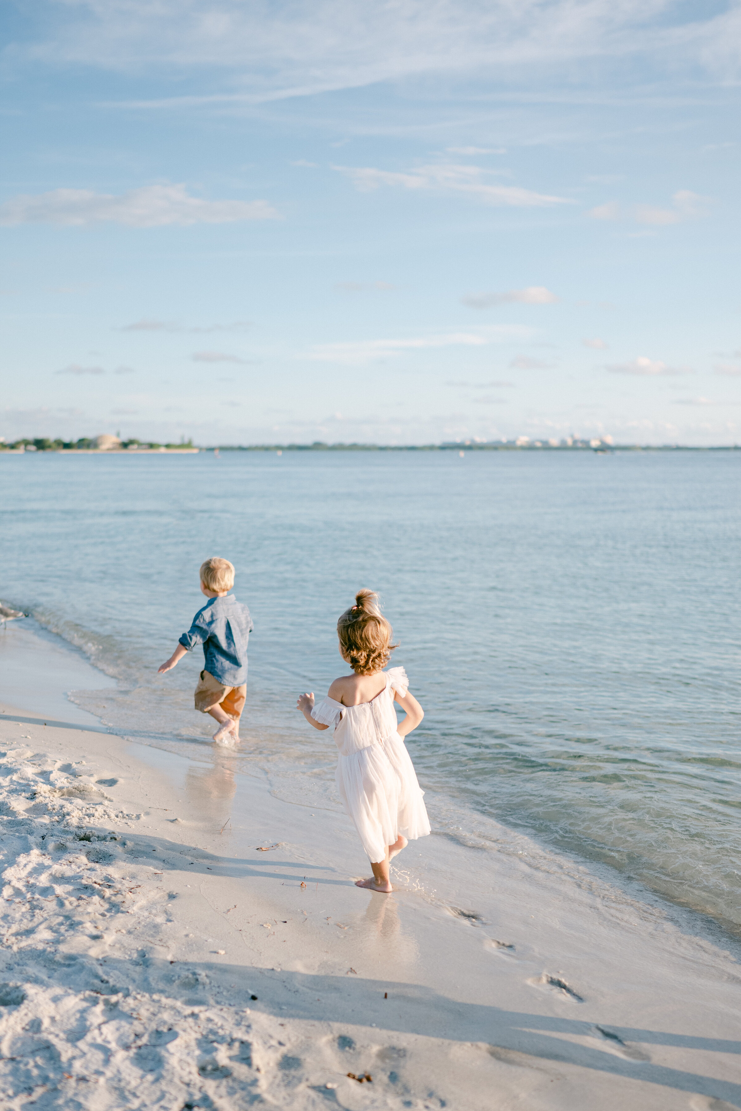 Kids running on the beach by Miami Family Photographer