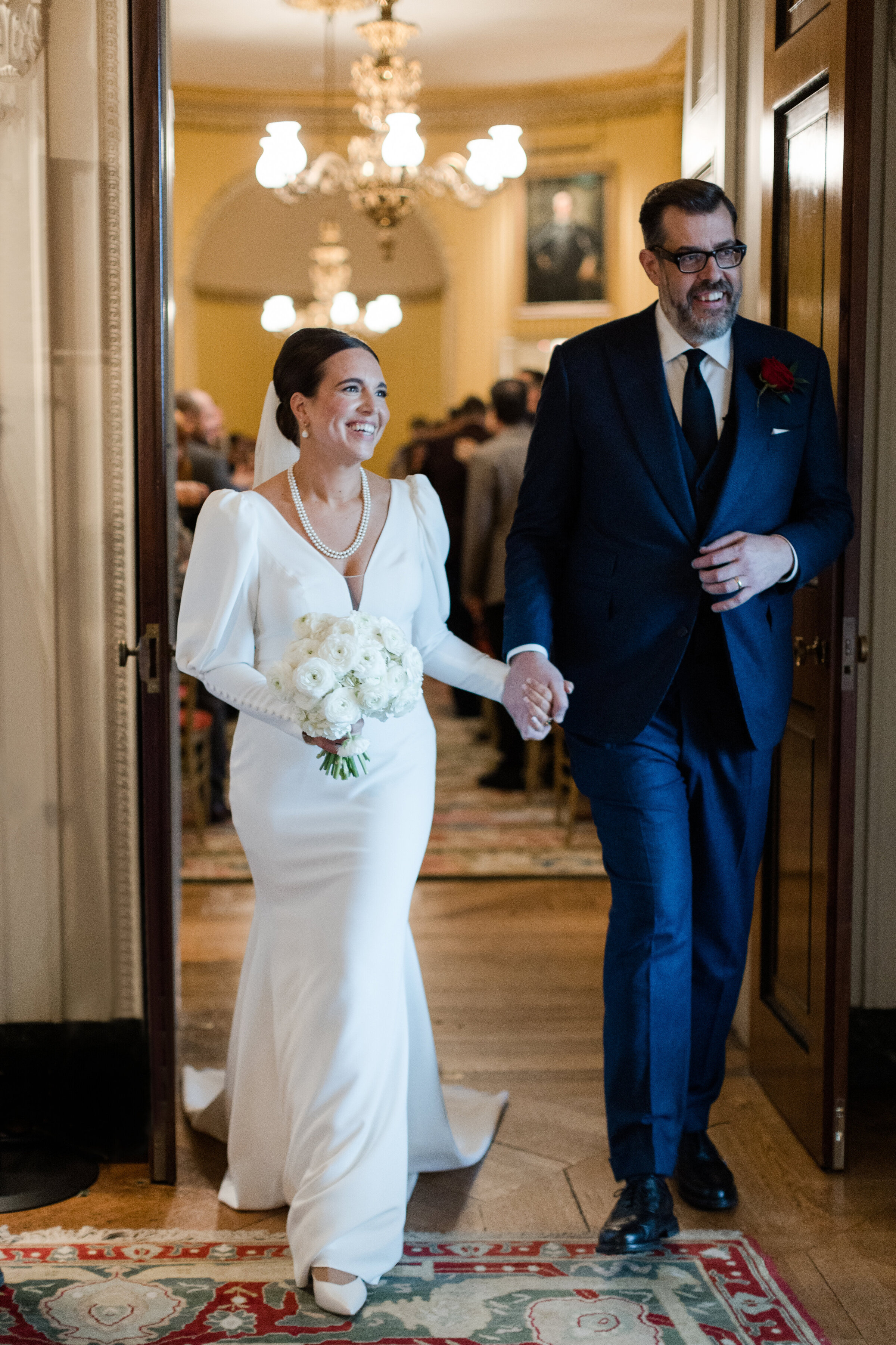 Pointless Tv Presenter Richard Osman and Doctor Who and The Hustle actress Ingrid Oliver in classic Pronovias gown exit the aisle on their wedding day at Goodwood House