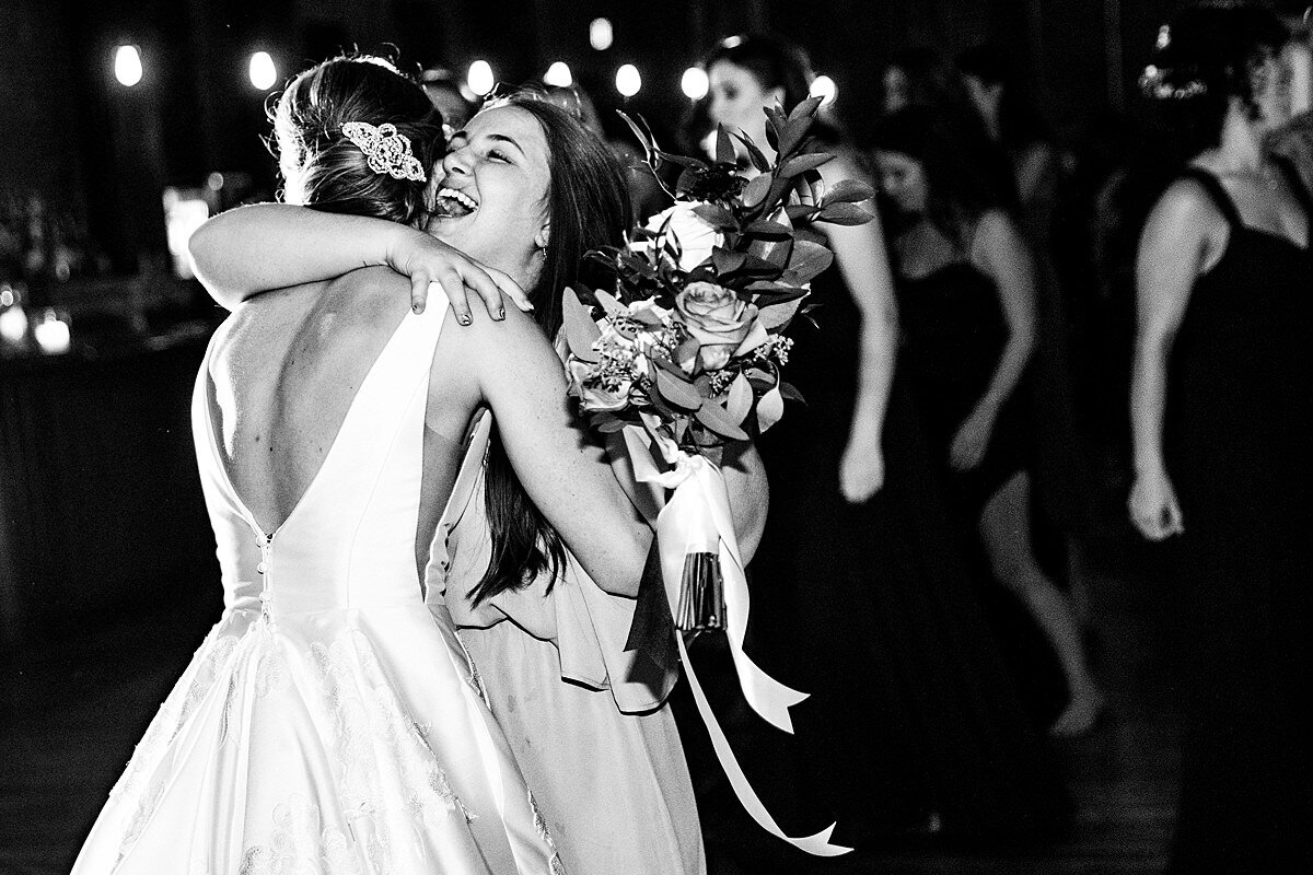 Black and White photo of bride hugging her friend who caught the bouquet during the bouquet toss