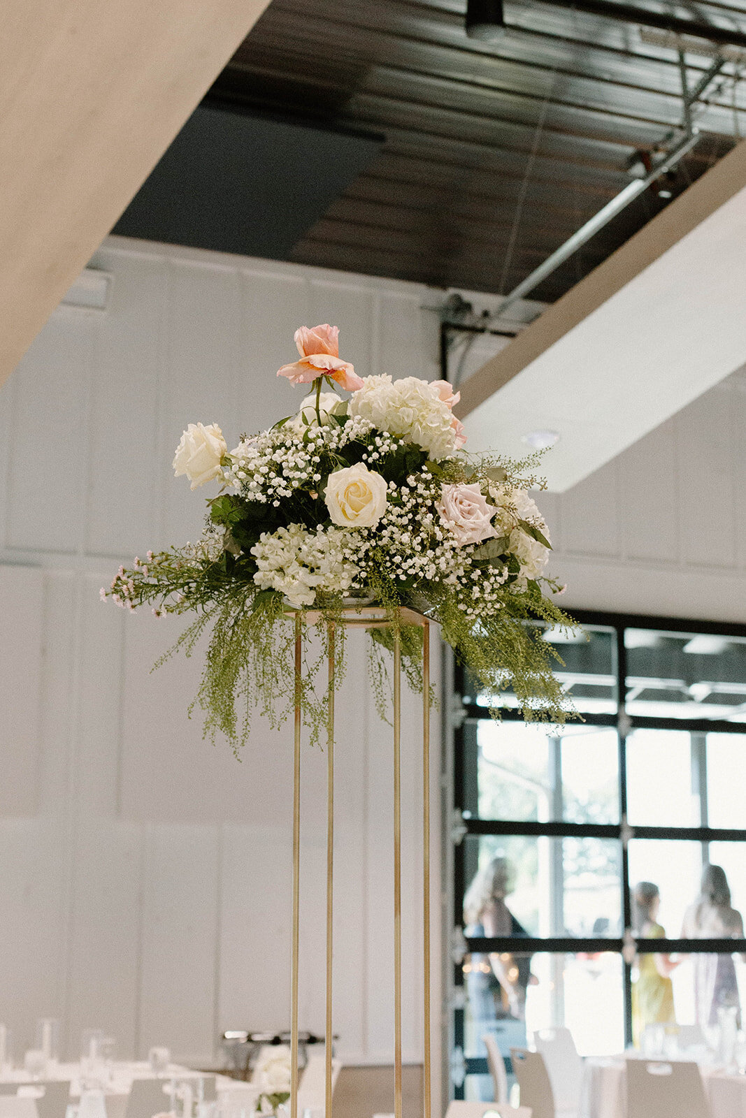 Stunning tall centerpiece featuring a sleek structure topped with lush florals, adding elegance and grandeur to the wedding reception in Columbus, OH. A perfect statement piece for a sophisticated and romantic ambiance.