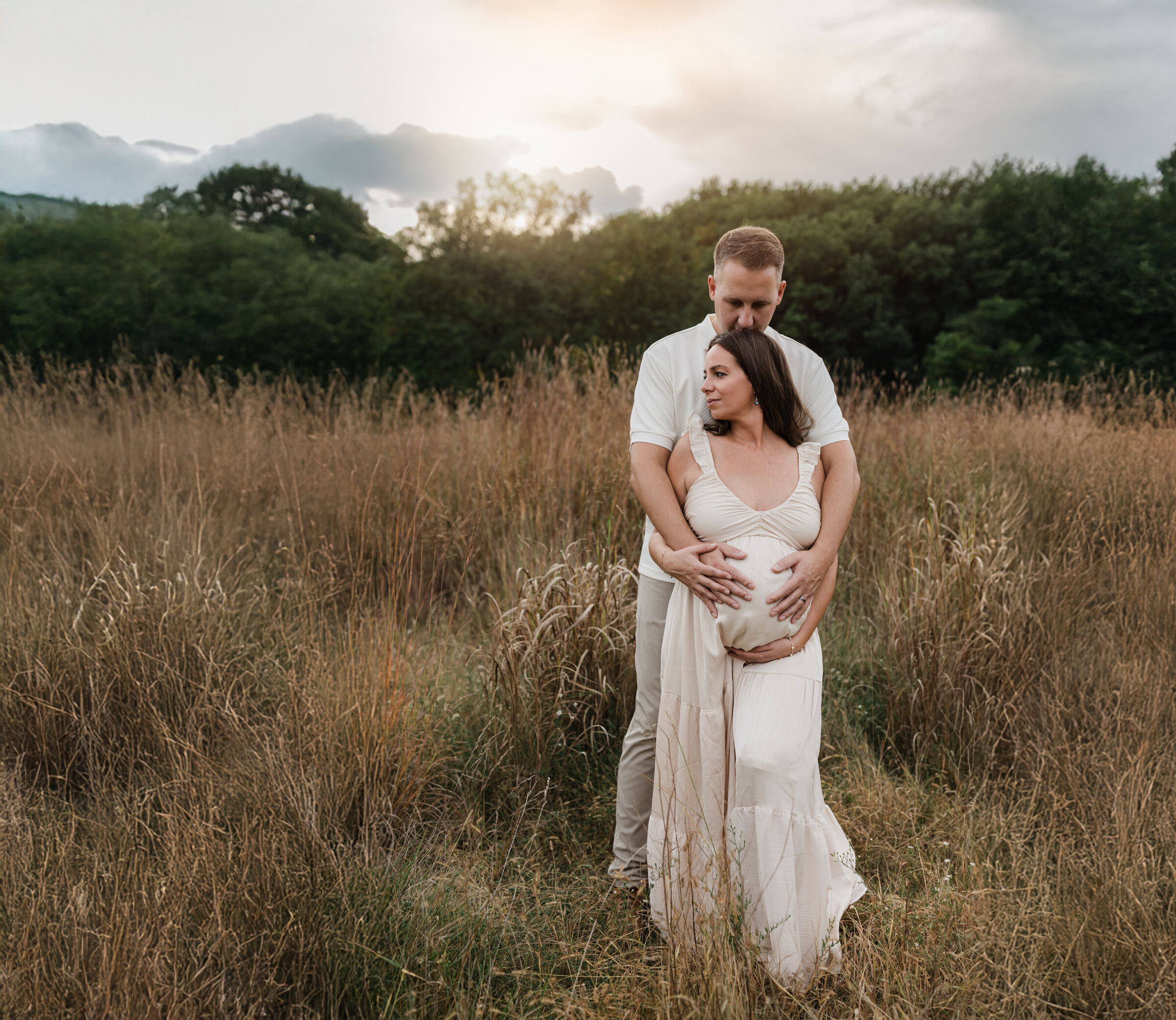 husband and pregnant wife in pink maternity gown holding baby bump for maternity photoshoot at westcreek reservation Cleveland family photographer