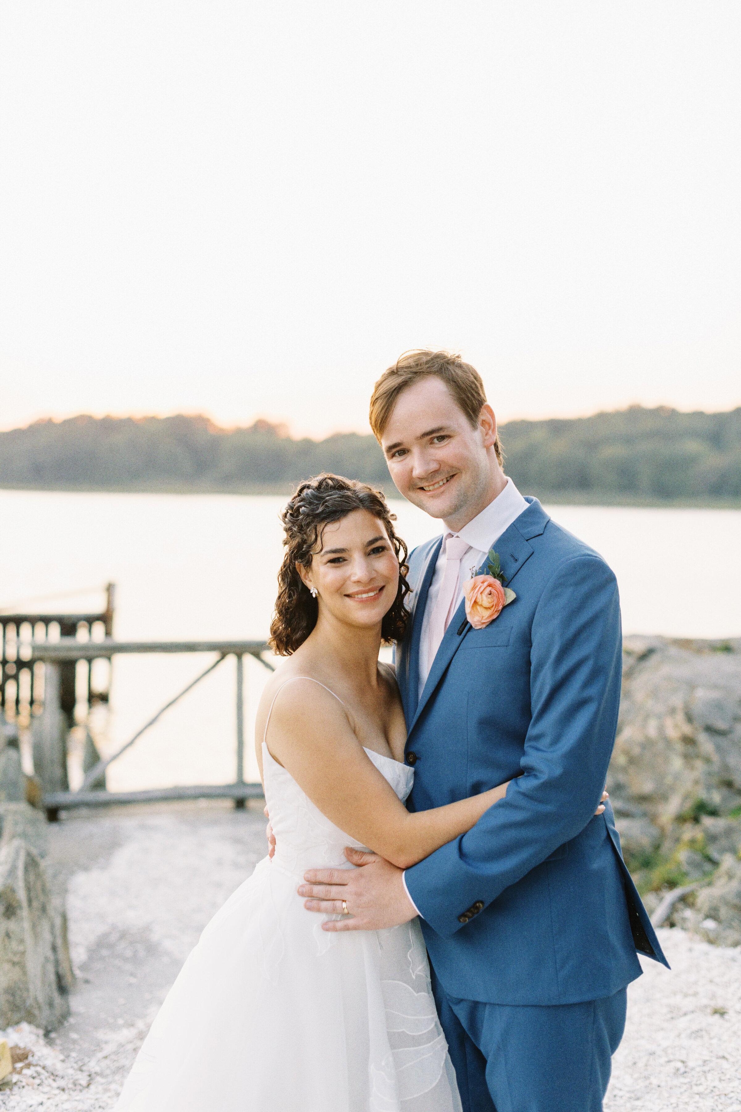 couple poses by the water at Mount Hope Farm wedding