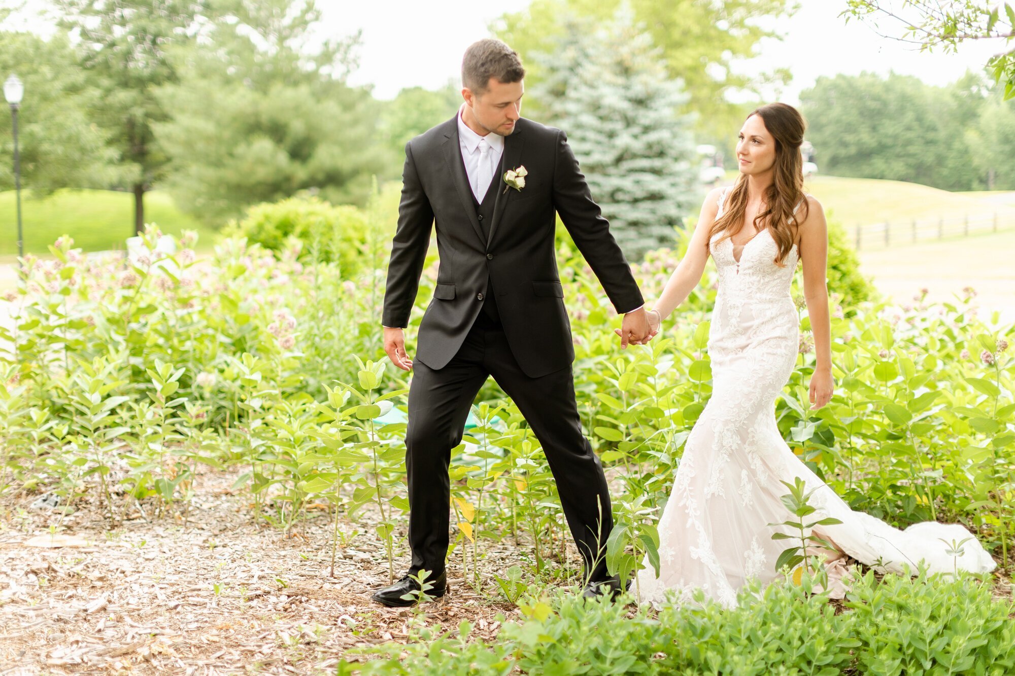 Bride and groom holding hands and walking, by wedding photographer minneapolis