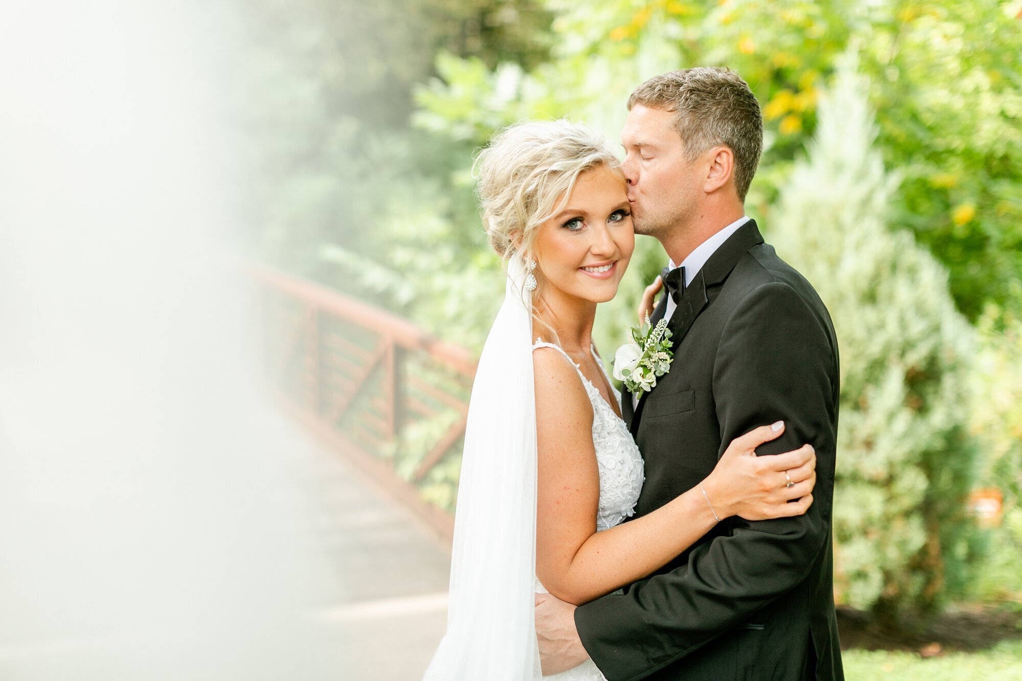Groom kissing bride's forehead taken by minneapolis wedding photographer