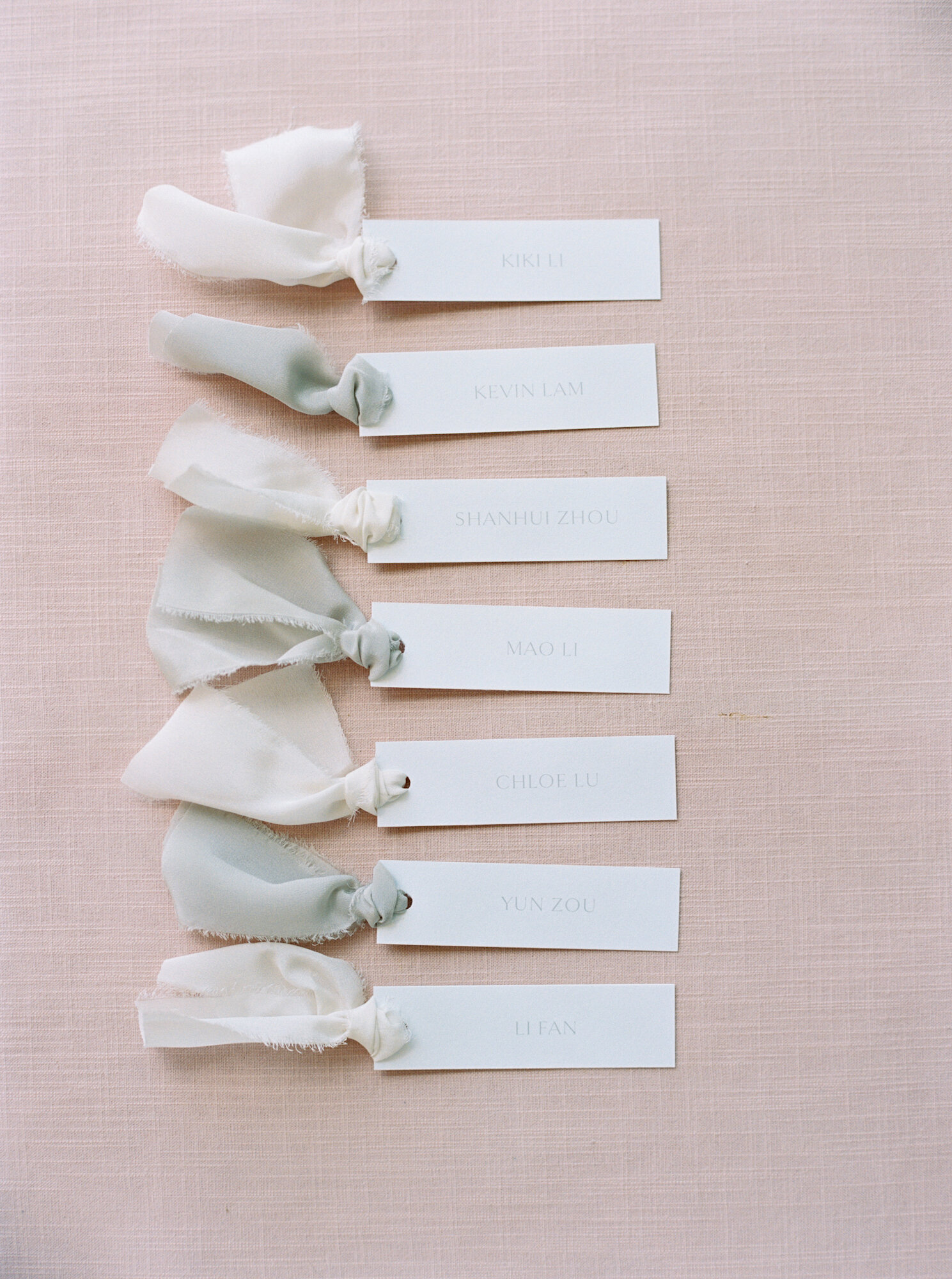 wedding favor tags on pink linen backdrop