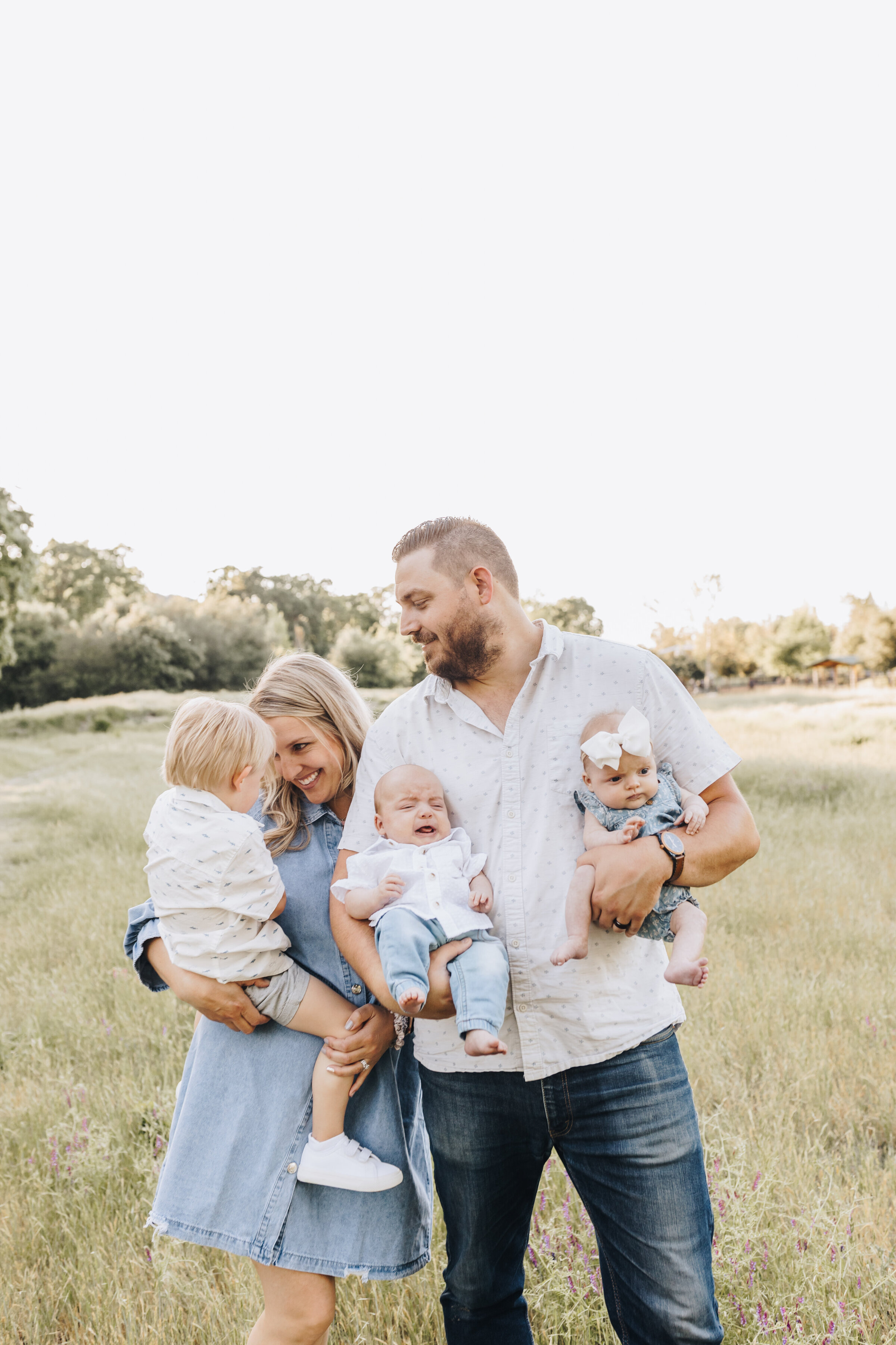Mom holds her son and dad holds twins during a family photography session