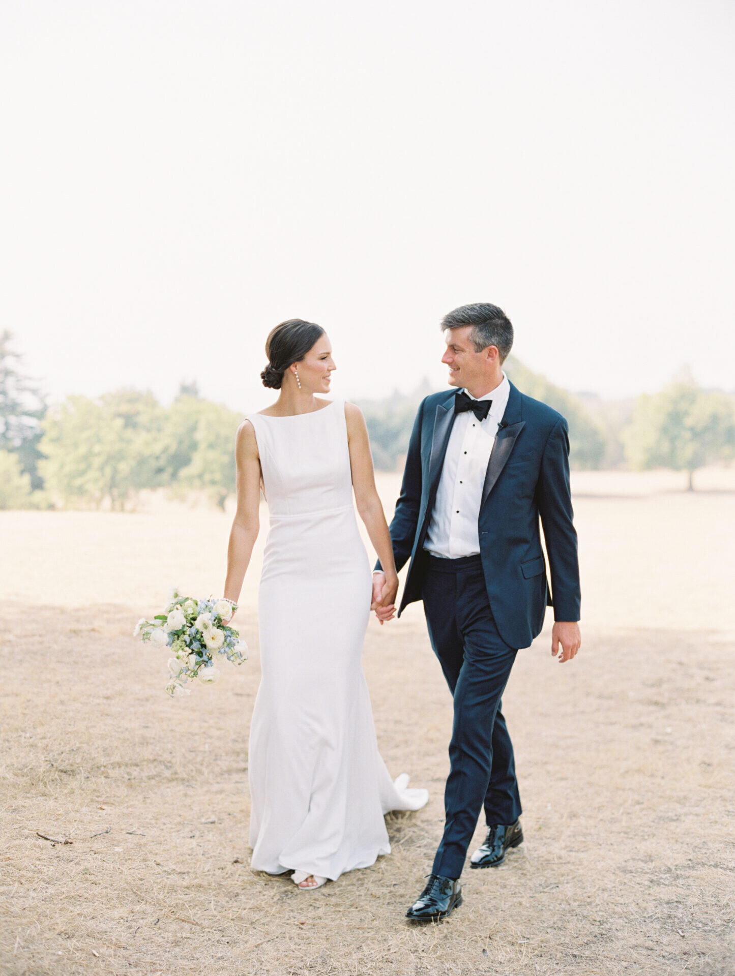 bride and groom walking holding hands at discovery park