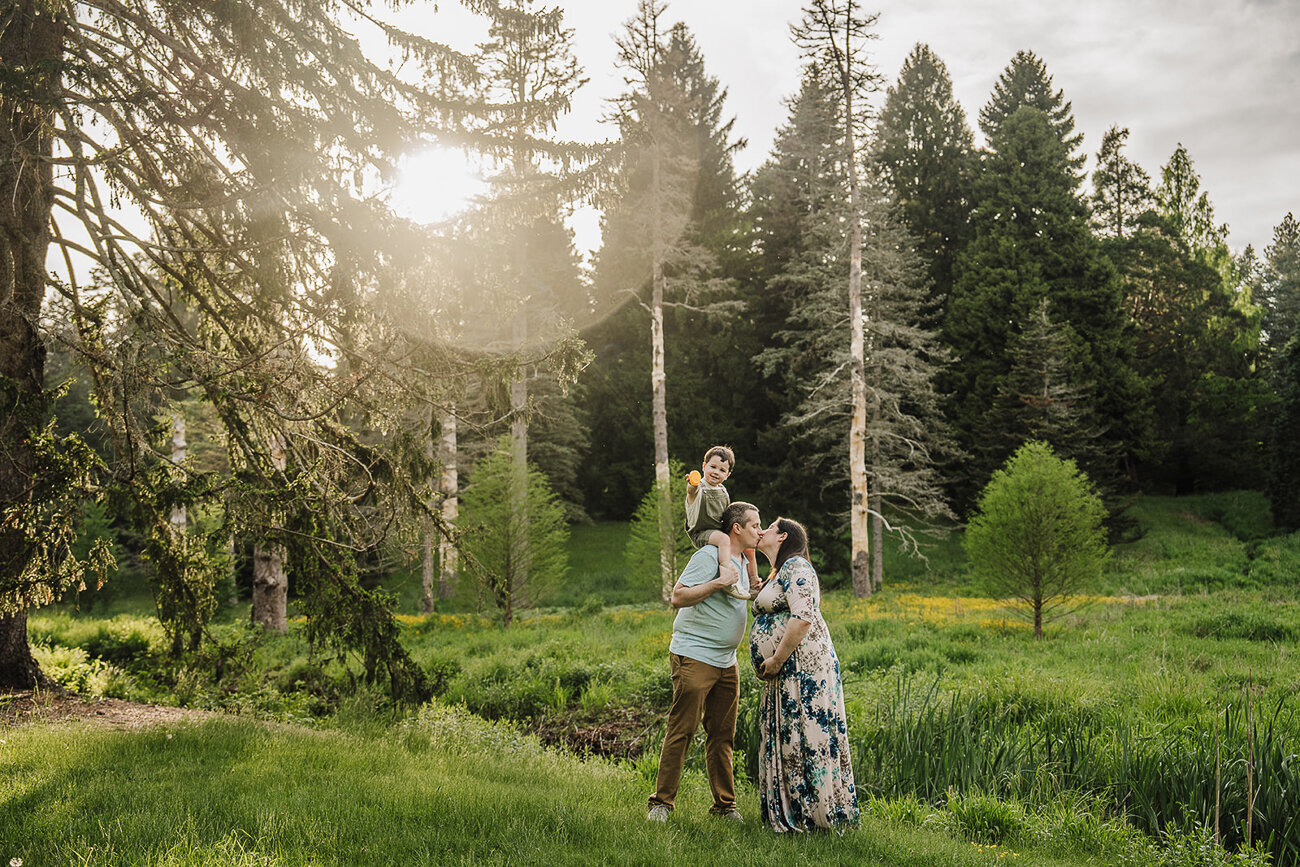 family expecting a baby poses during maternity photos in boston