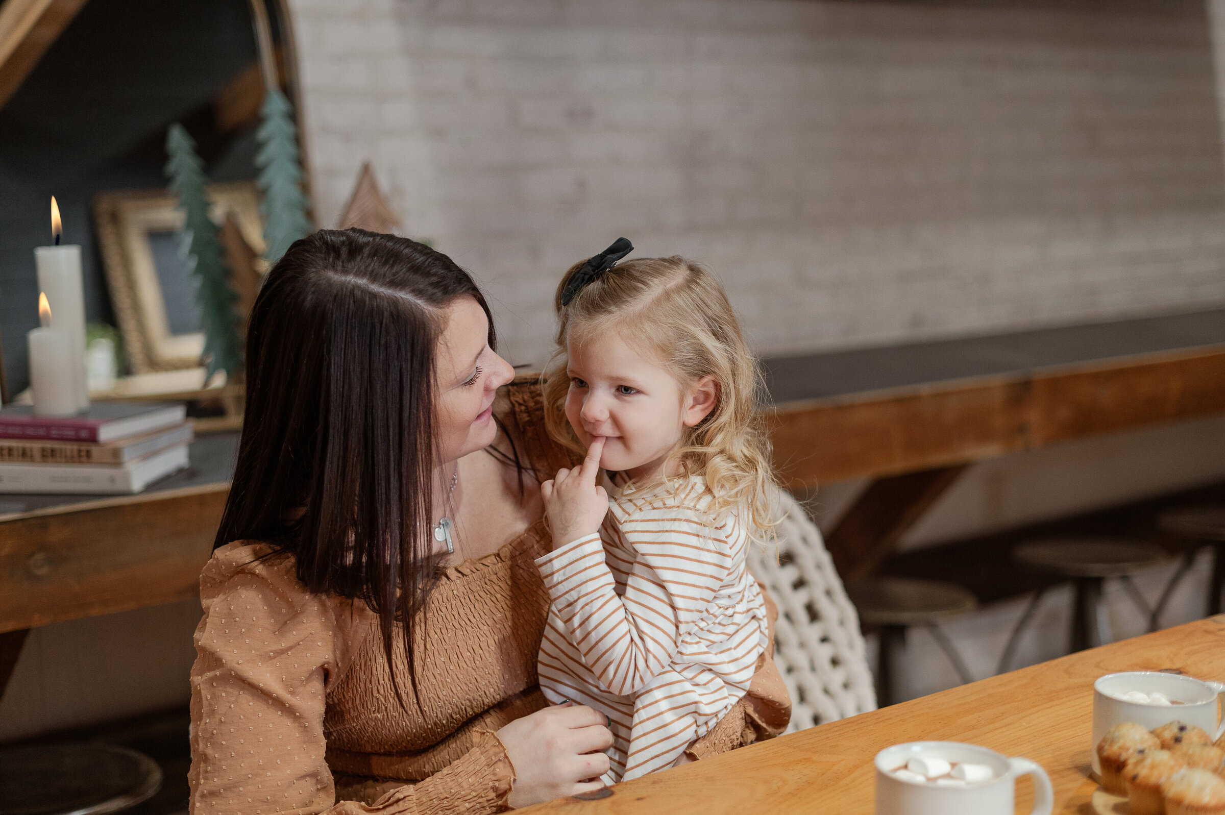 A mother and daughter laughing together while baking at the kitchen table during a Day in the Life session in baltimore
