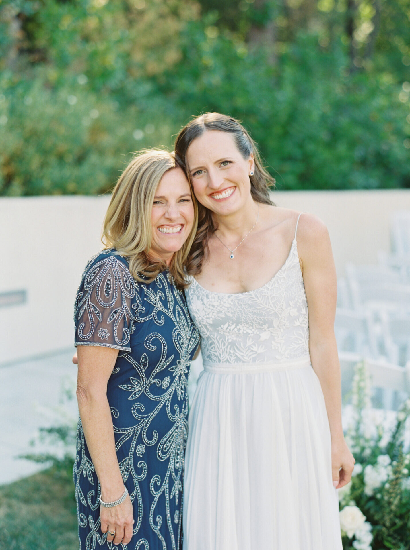 bride and her mom hug and smile for the camera