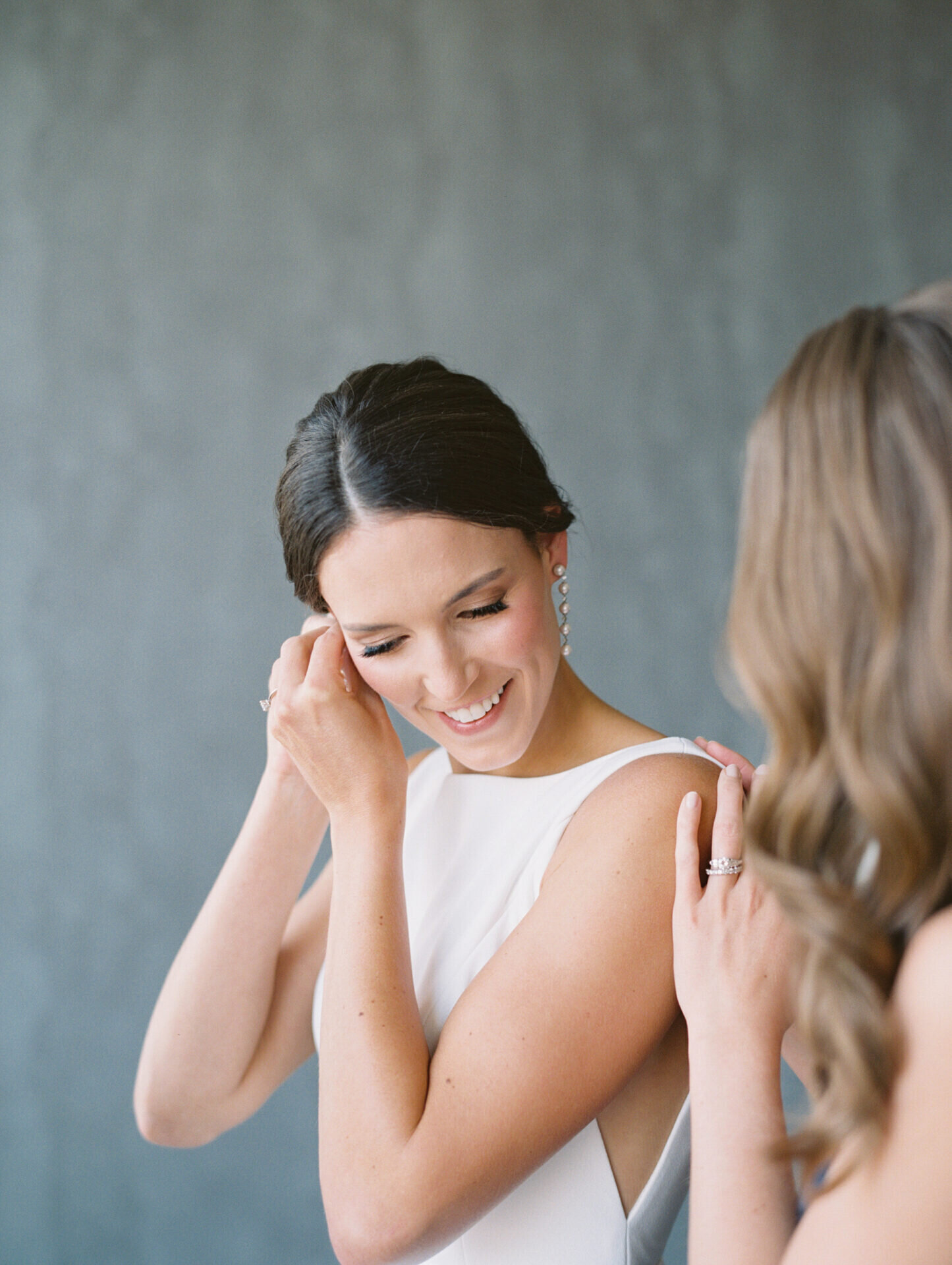 bride putting earrings on