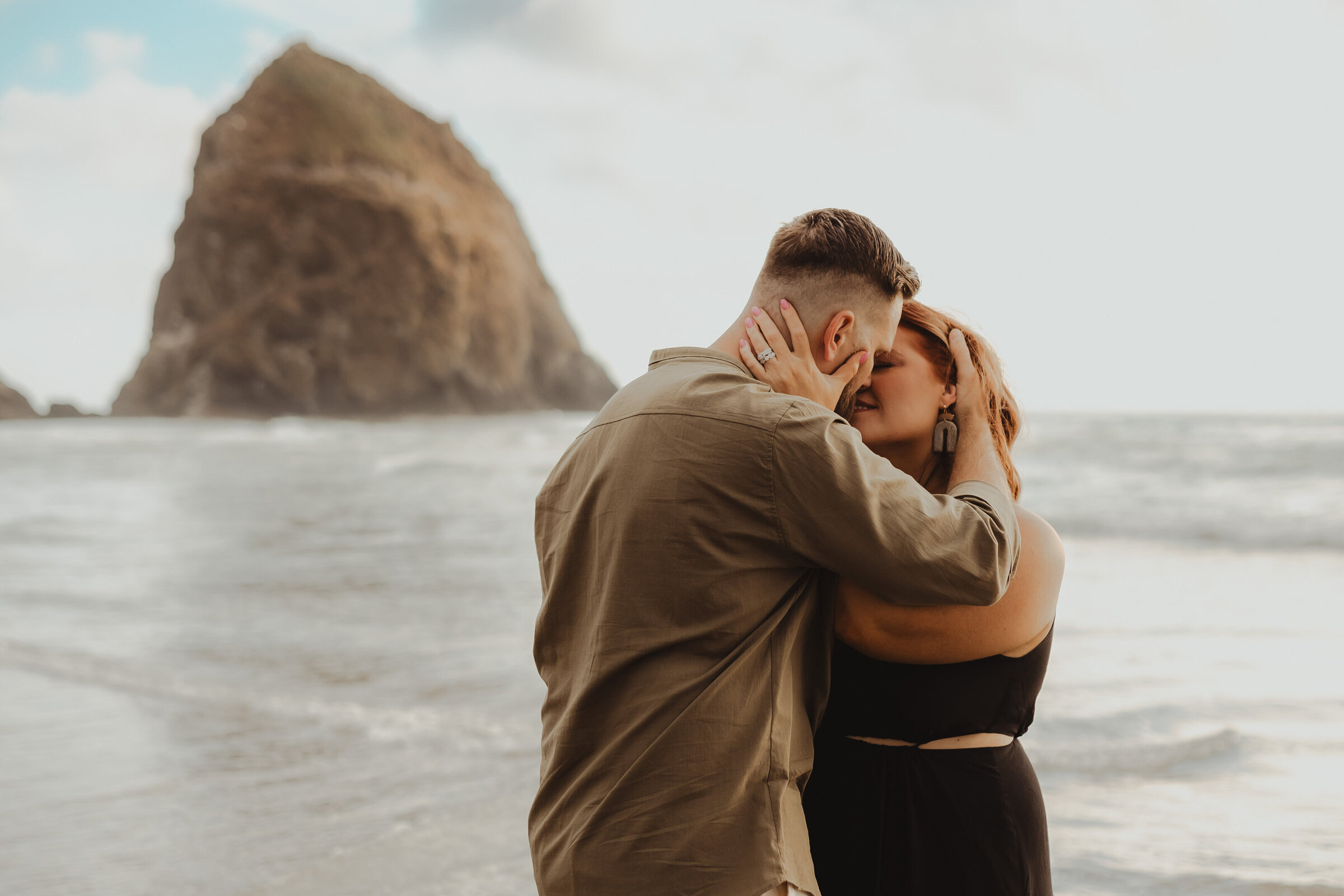 couple-kissing-in-front-of-haystack-rock-at-cannon-beach
