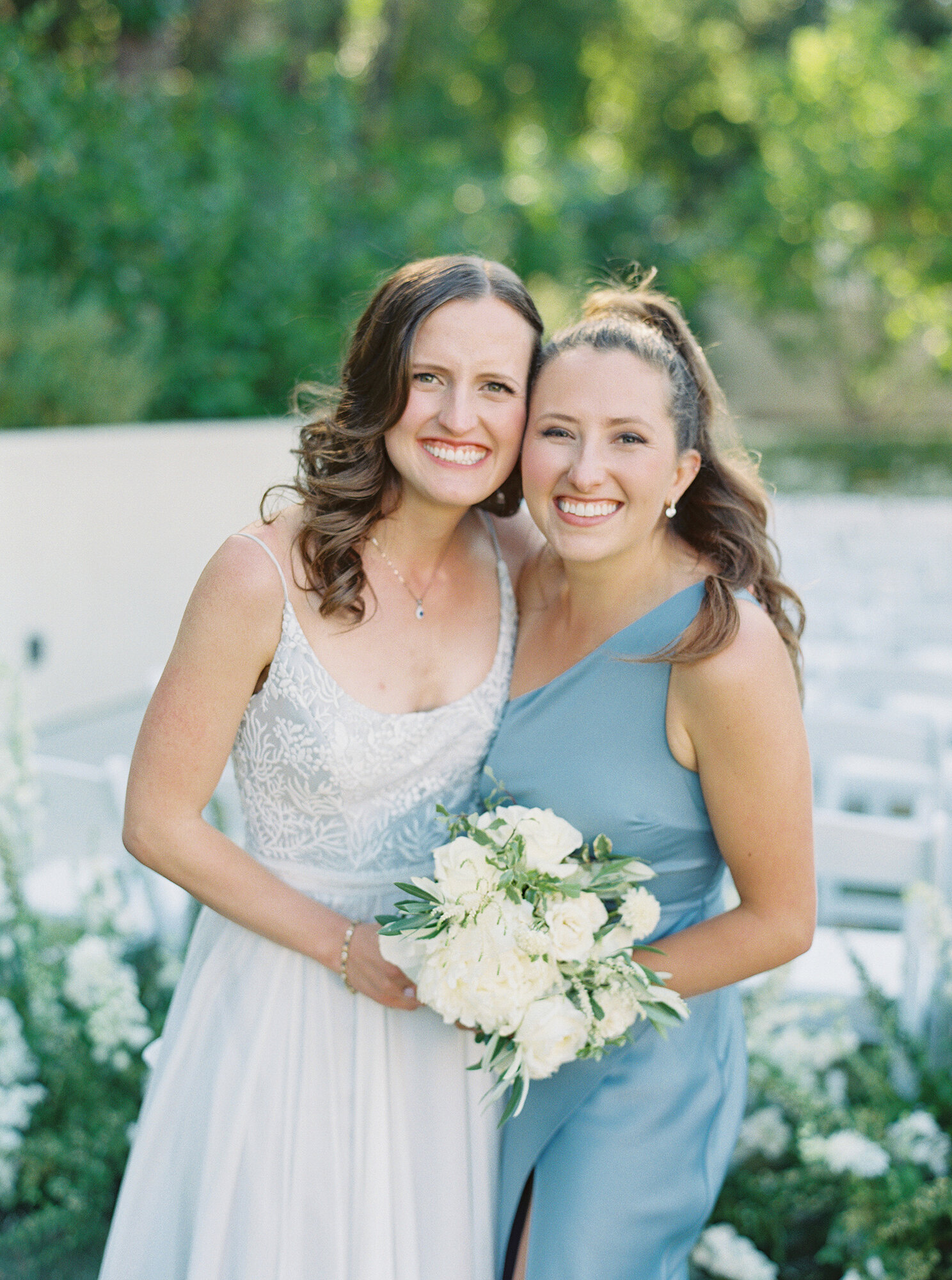 light blue and white wedding bride hugging her bridesmaid