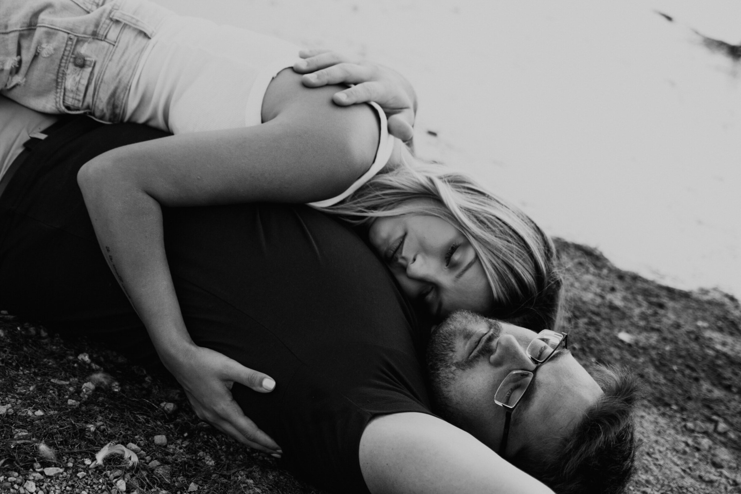 couple-laying-on-lake-beach