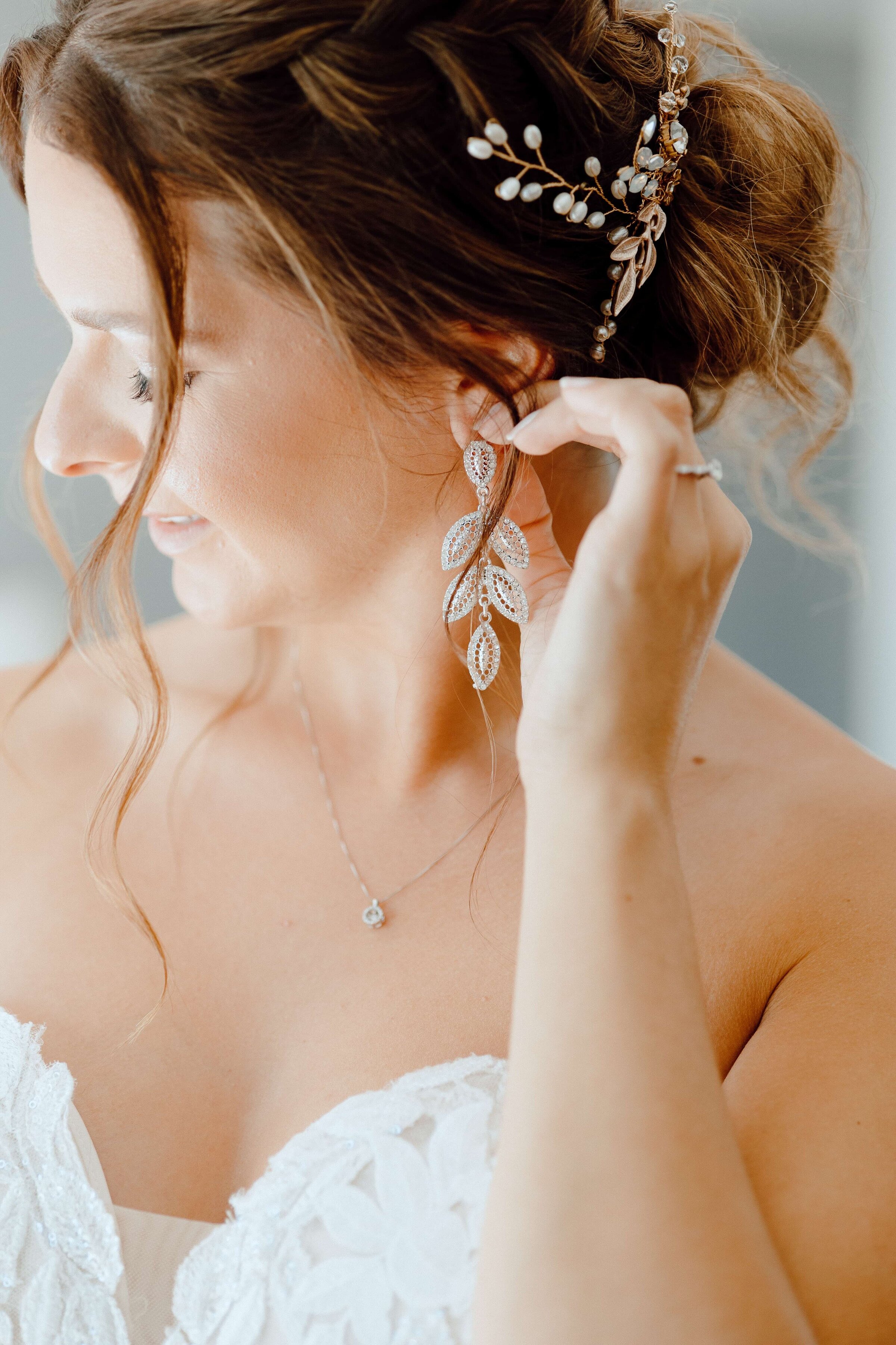 bride putting on earrings