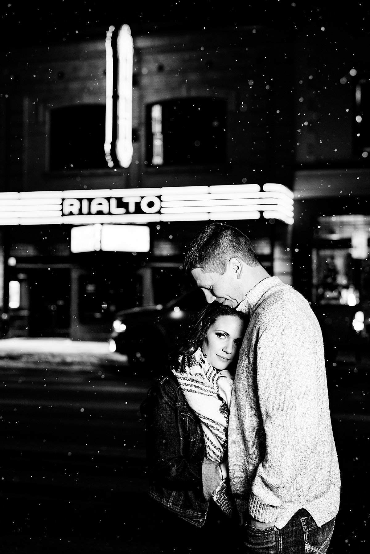 Black and white nighttime photo of couple in front of Rialto in downtown Bozeman