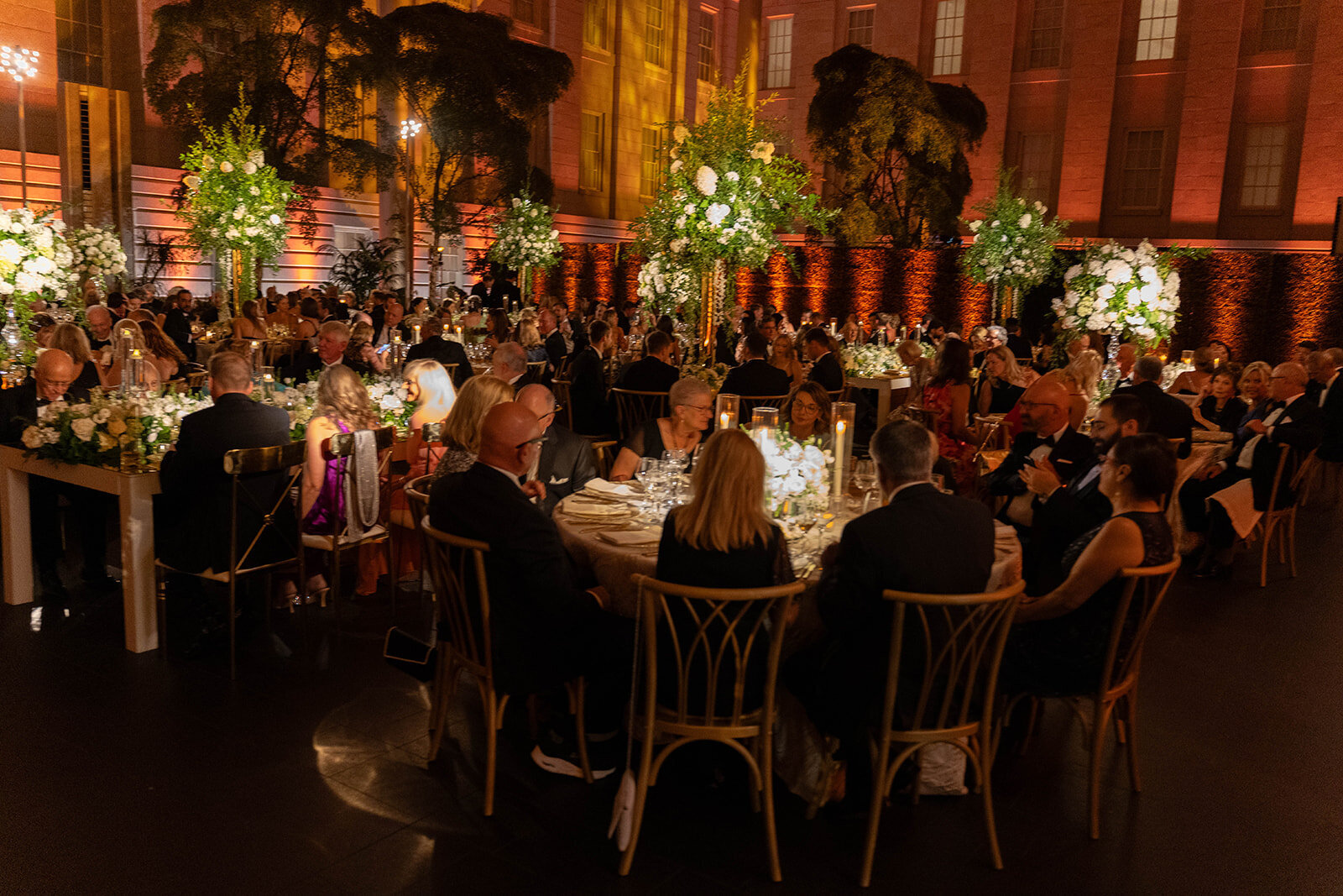 Elegant wedding reception under the glass canopy at the Smithsonian National Portrait Gallery in Washington DC, with guests dancing and celebrating, photographed by Mari Harsan Studios.