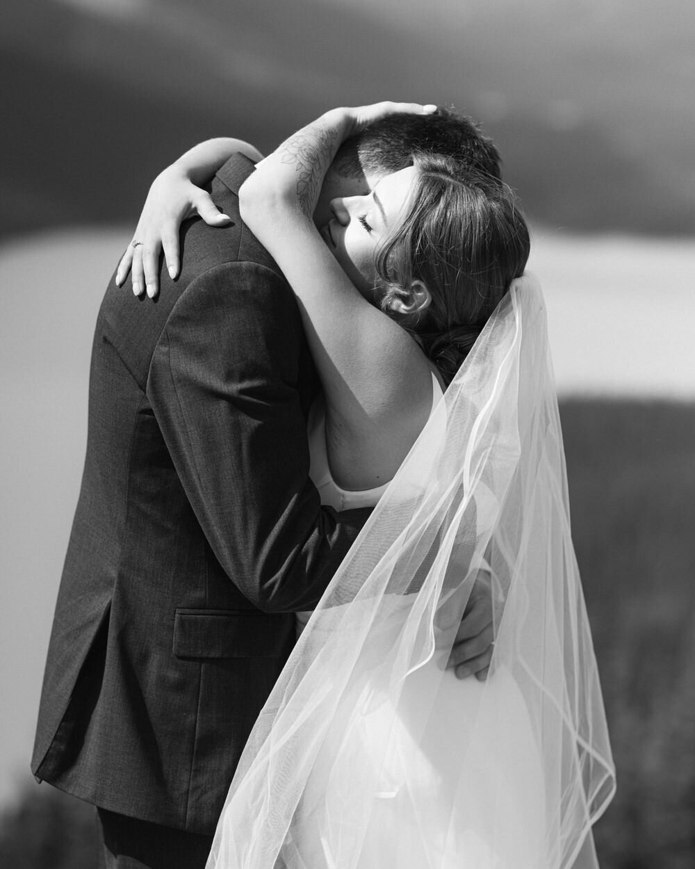A deeply emotional yet joyful Lomint photograph capturing the couple in a heartfelt embrace after exchanging their vows at Peyto Lake along the Icefields Parkway in Banff National Park. Surrounded by breathtaking mountain views, this moment encapsulates the raw beauty, intimacy, and pure connection of their unforgettable elopement day.