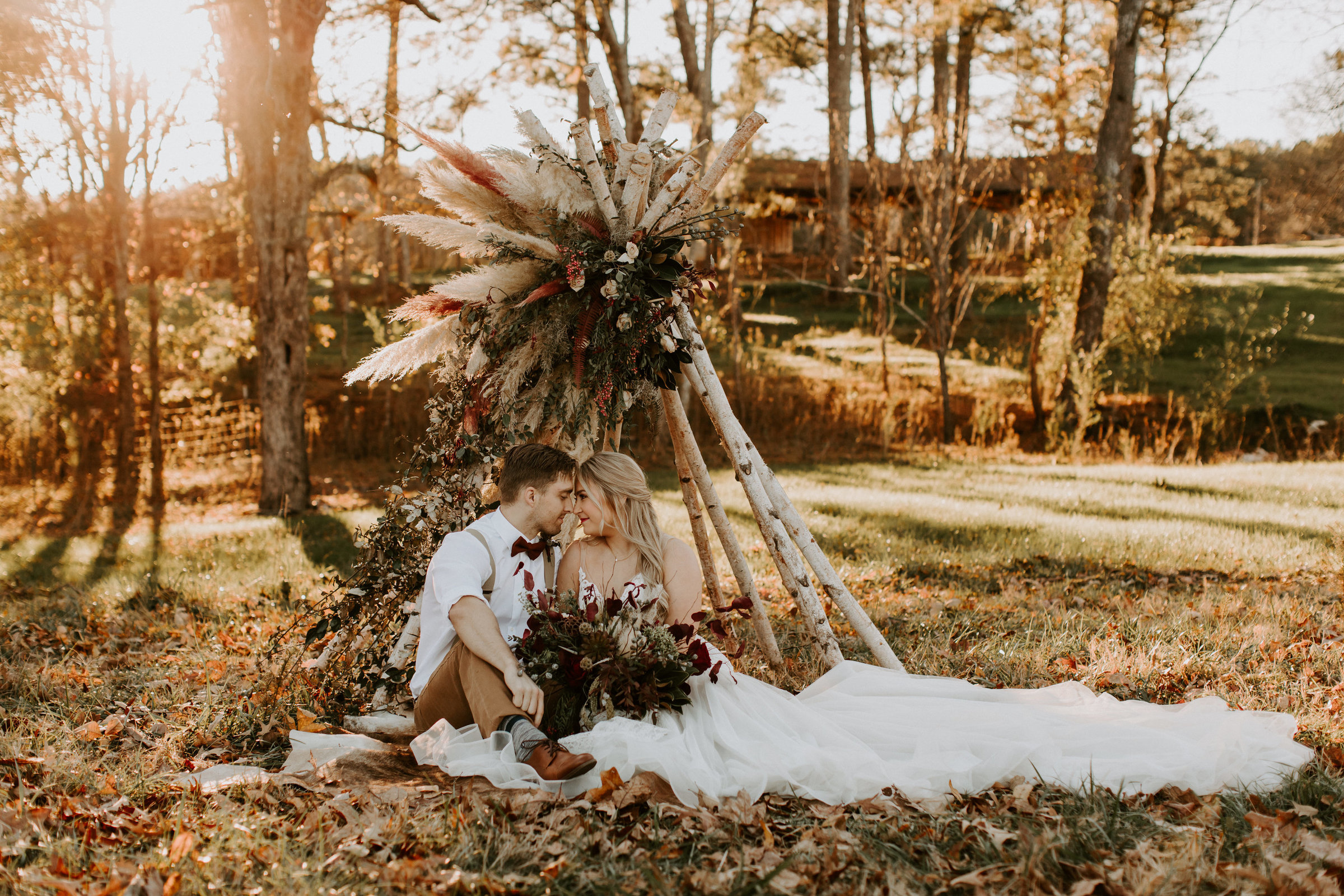 bride & groom sitting in a field in boulder colorado on their wedding day