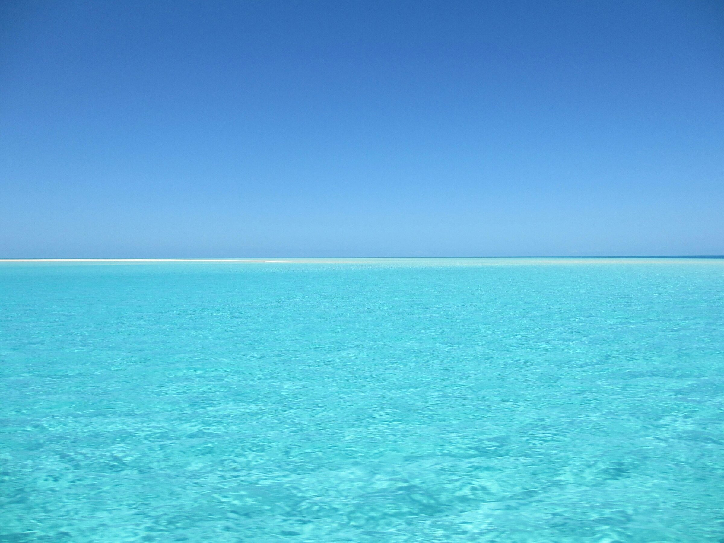 Image of calm ocean view with teal water and blue sky