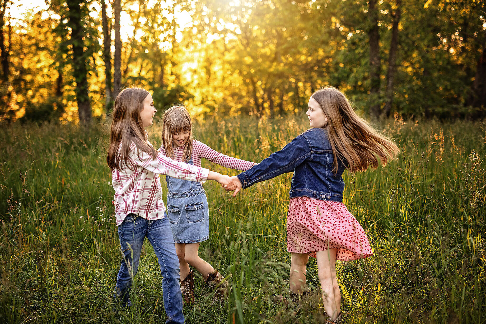 3 sisters playing ring around the rosie in tall grass