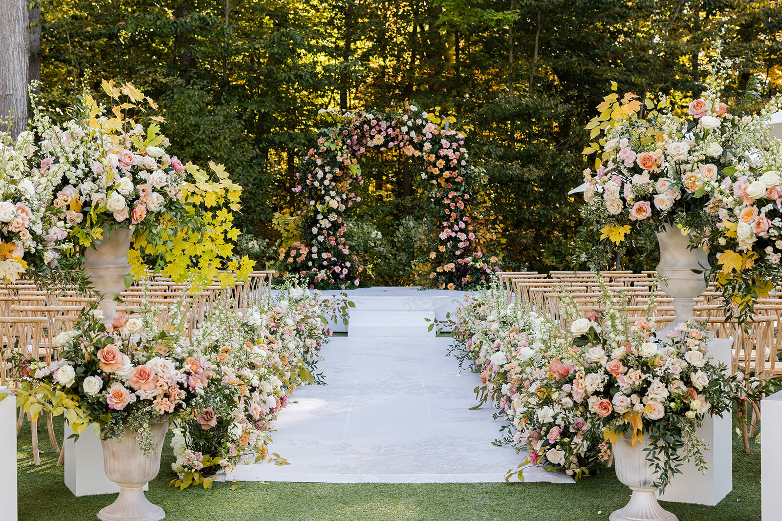 Lush garden wedding with arch and a river of aisle flowers 