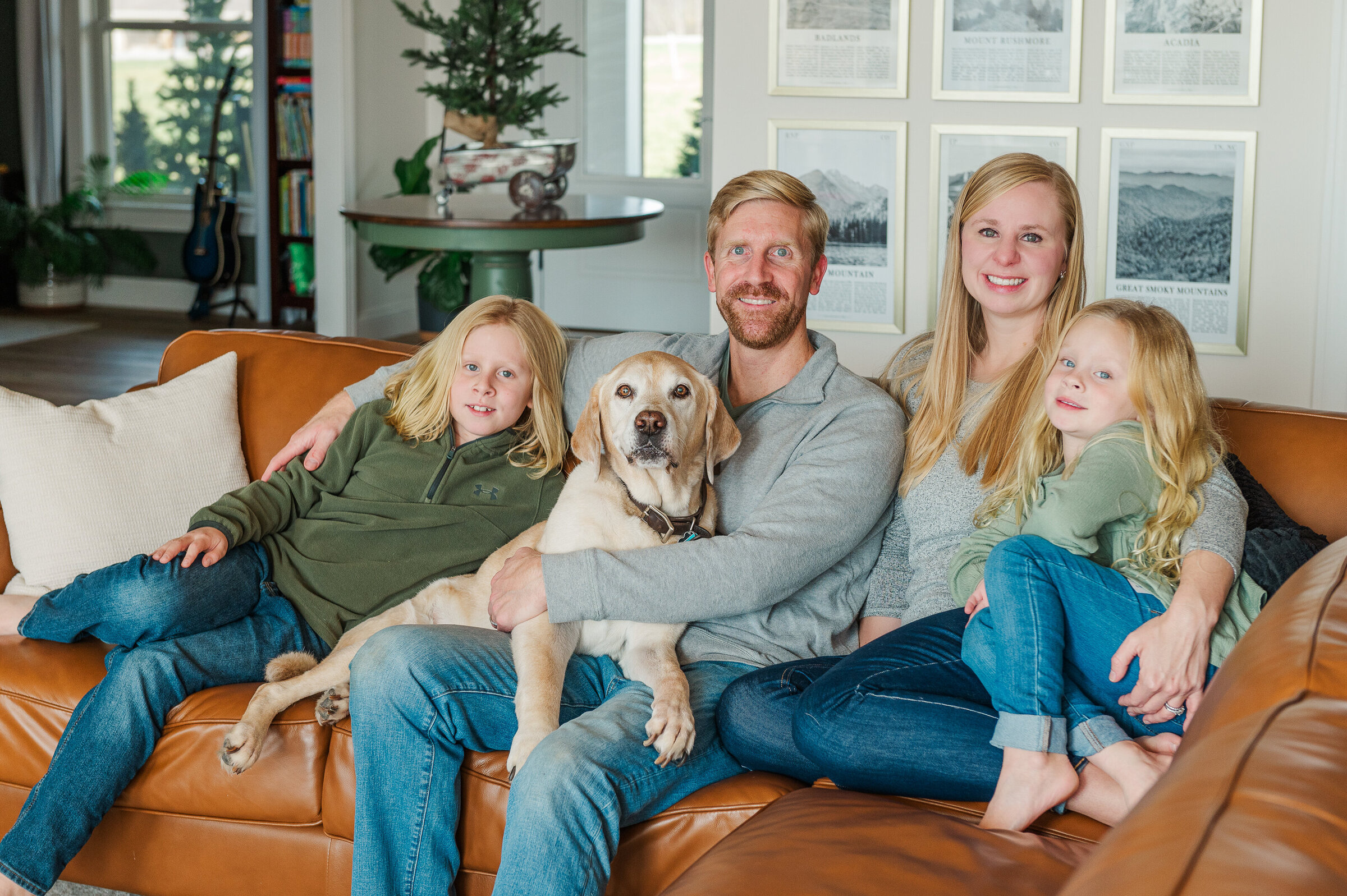 family of four posing on their couch with their dog in lancaster pa