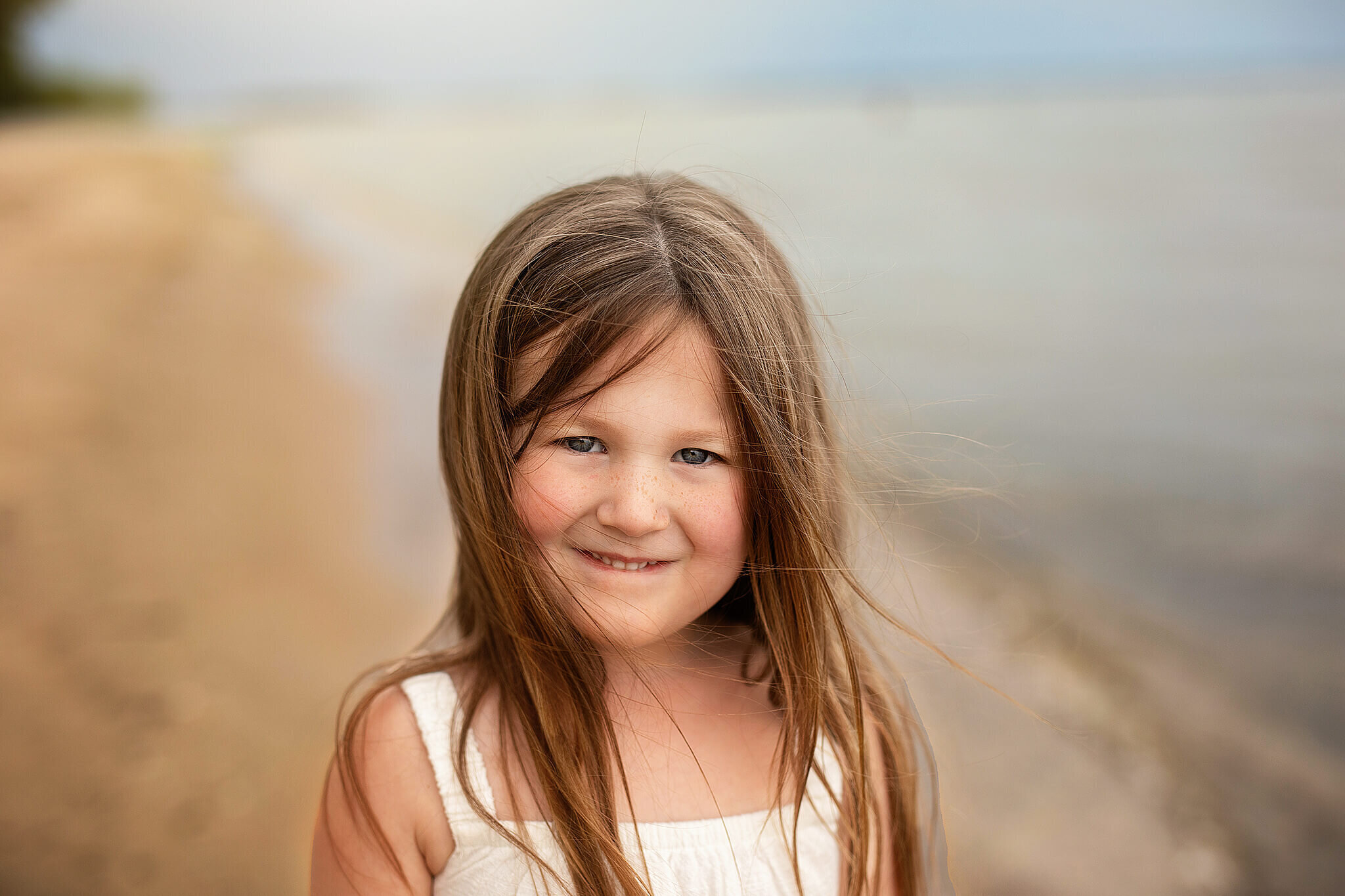 Little girl with brown hair standing on  east harbor beach at Lake Erier