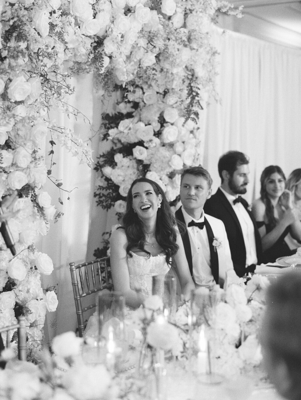 bride and groom laugh during speech at wedding