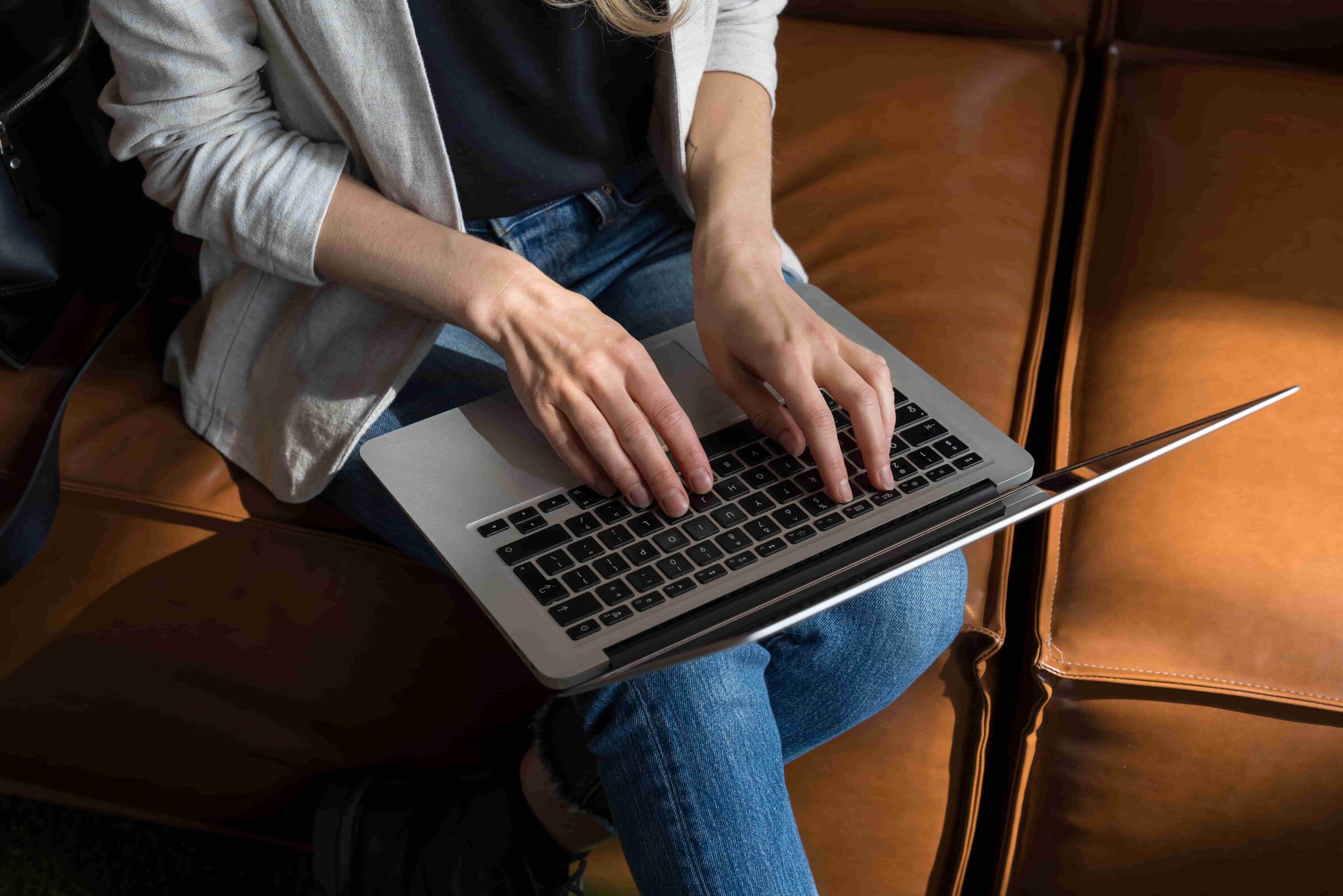 The image depicts a woman signing onto her laptop to watch ITN’s free video series about how you can discover your dream career!