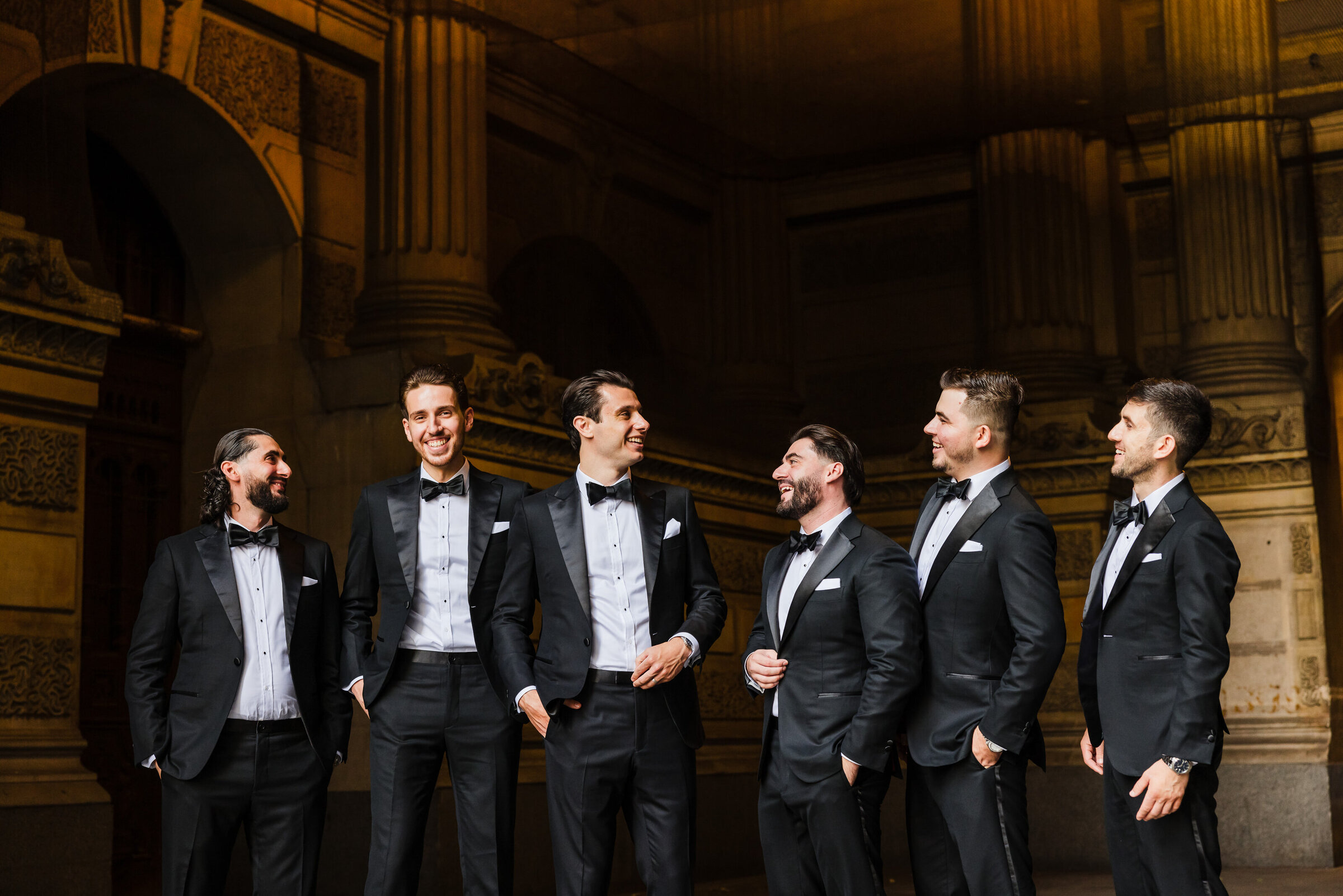 Groomsmen candidly laughing  at Philadelphia City Hall
