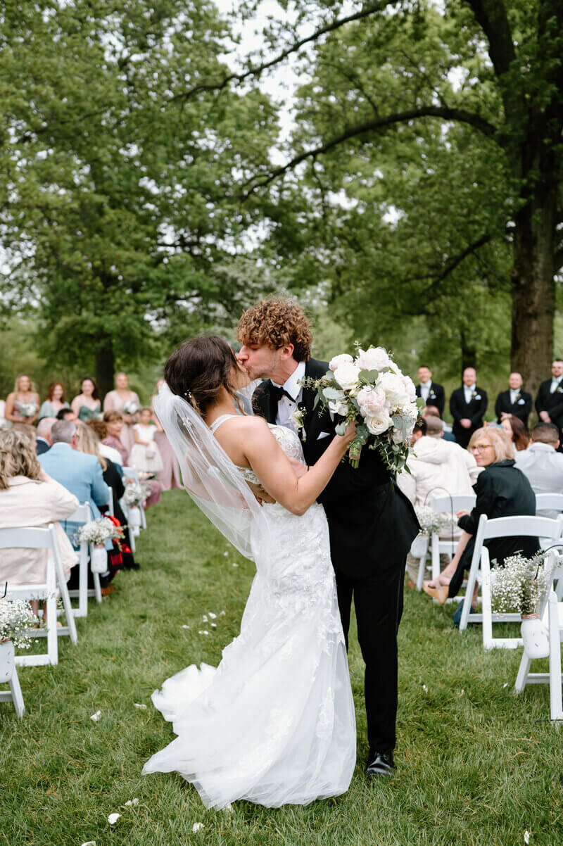 bride and groom kissing down the aisle by wedding photographers lexington ky