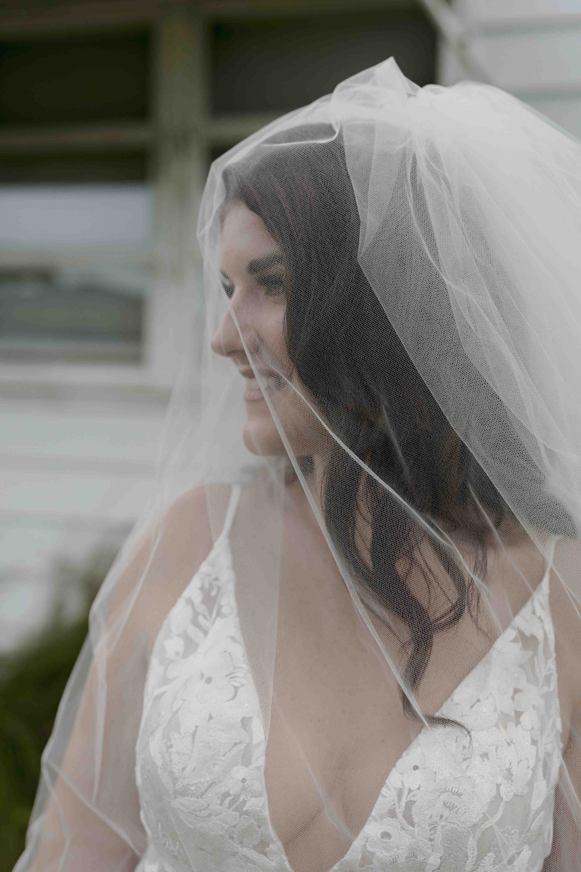 Bride wearing white dress with veil covering her face