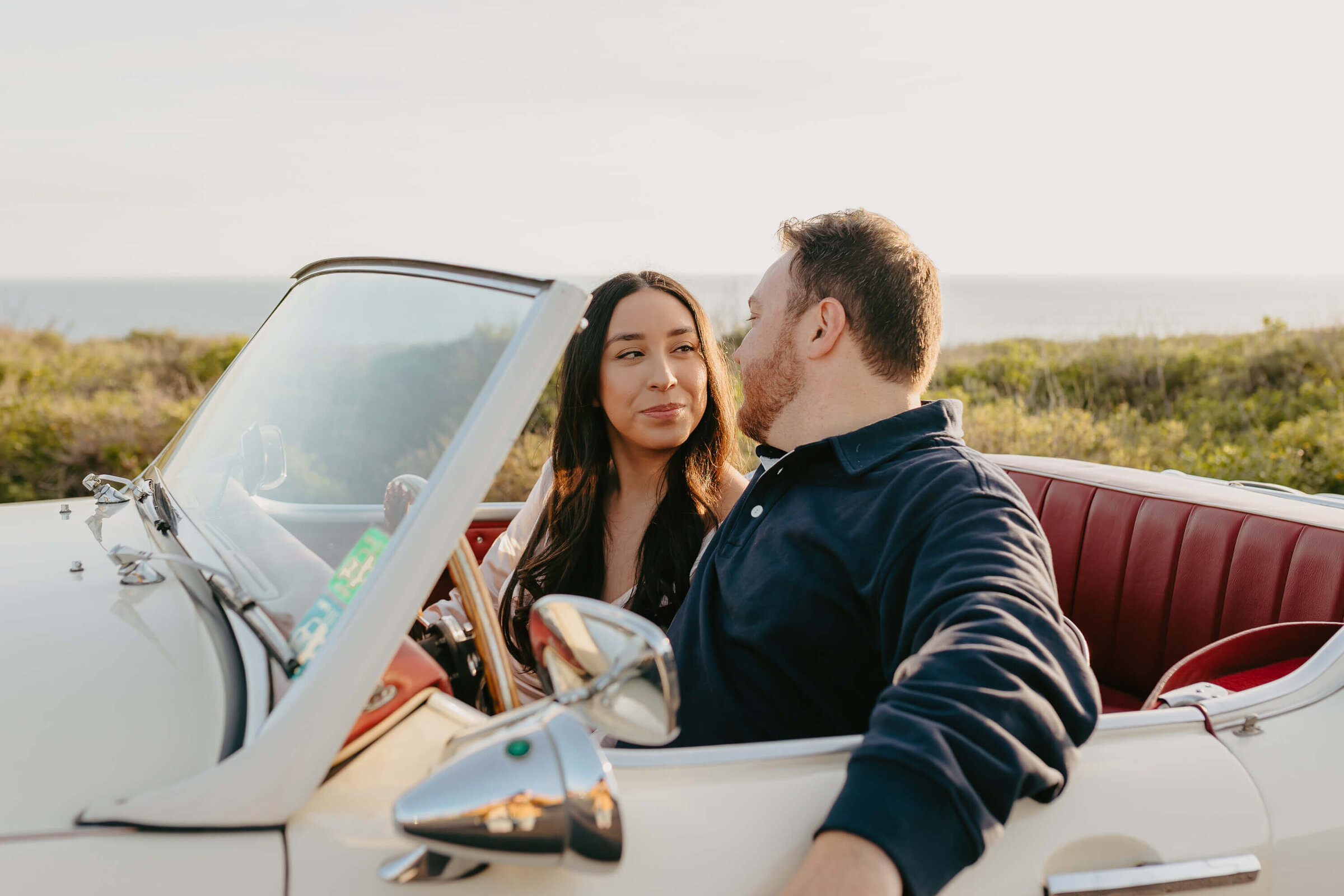 Couple looking at each other in vintage car at Crystal Cove